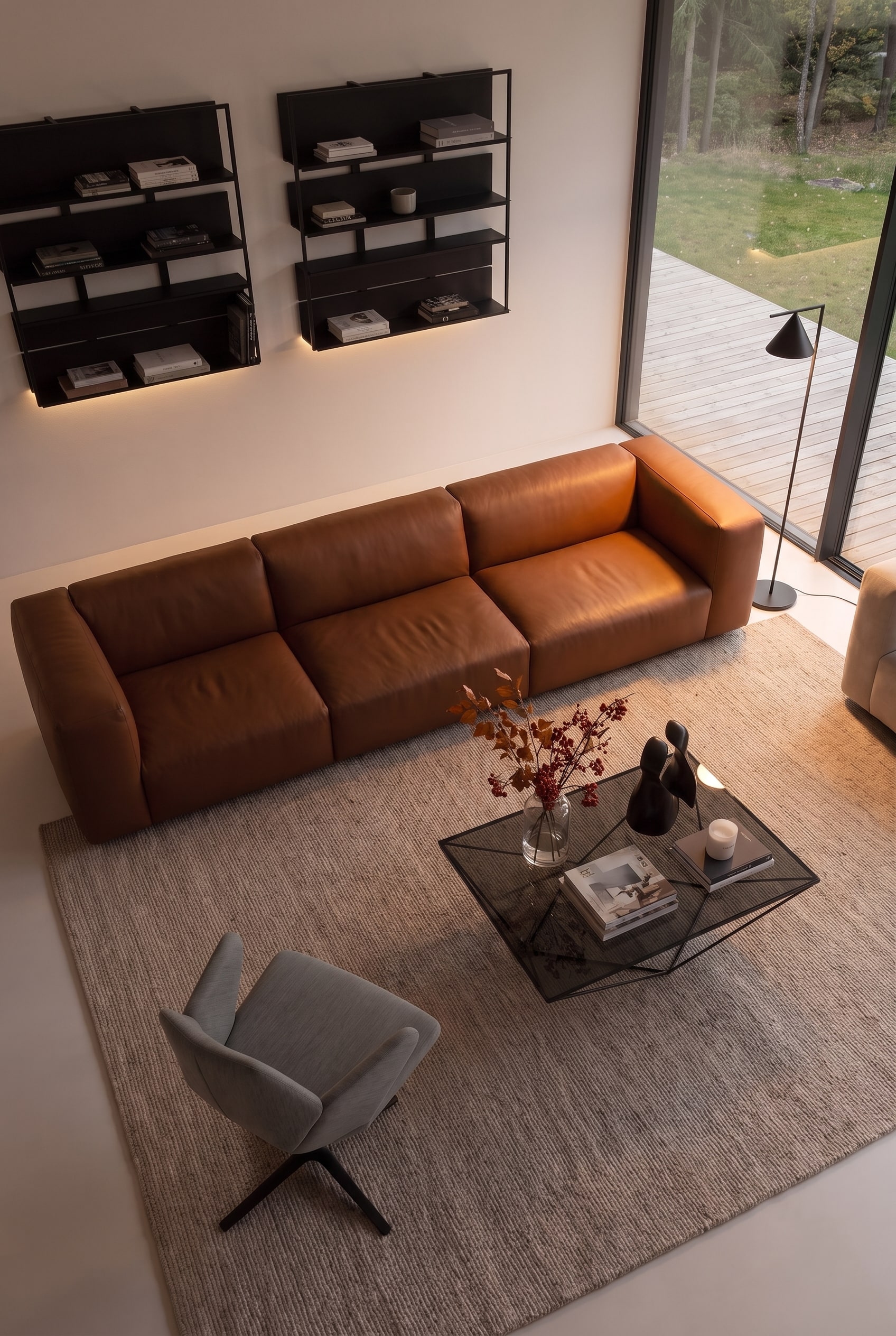 Vue plongeante sur un salon avec un canap&eacute; &eacute;l&eacute;gant, des fauteuils et une table basse parfaitement espac&eacute;s les uns des autres.