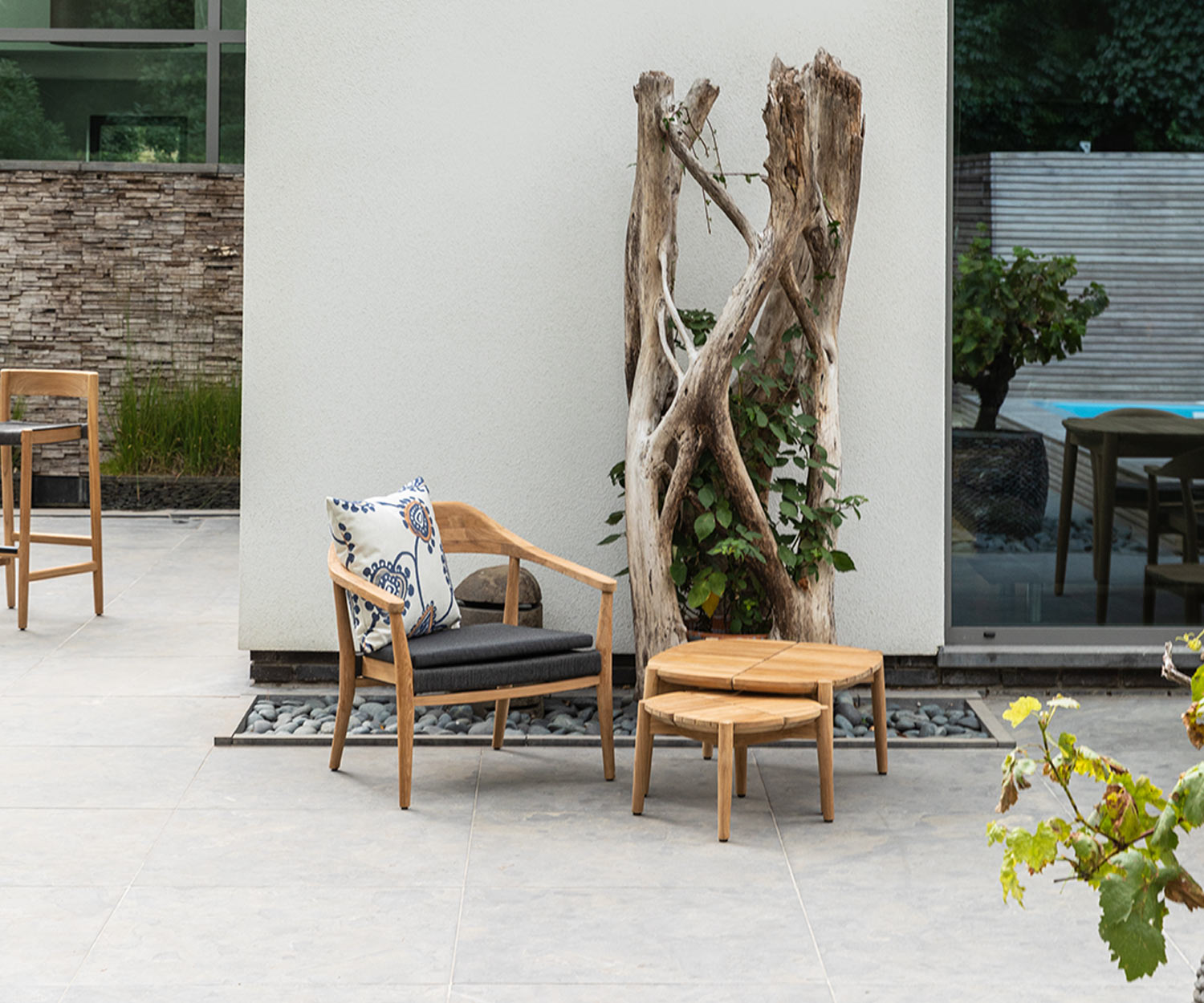 Quadratischer Oasiq Copenhagen Outdoor Tisch mit Stuhl und Baum auf Terrasse Quadratischer Oasiq Copenhagen Outdoor Tisch mit Stuhl und Baum auf Terrasse
