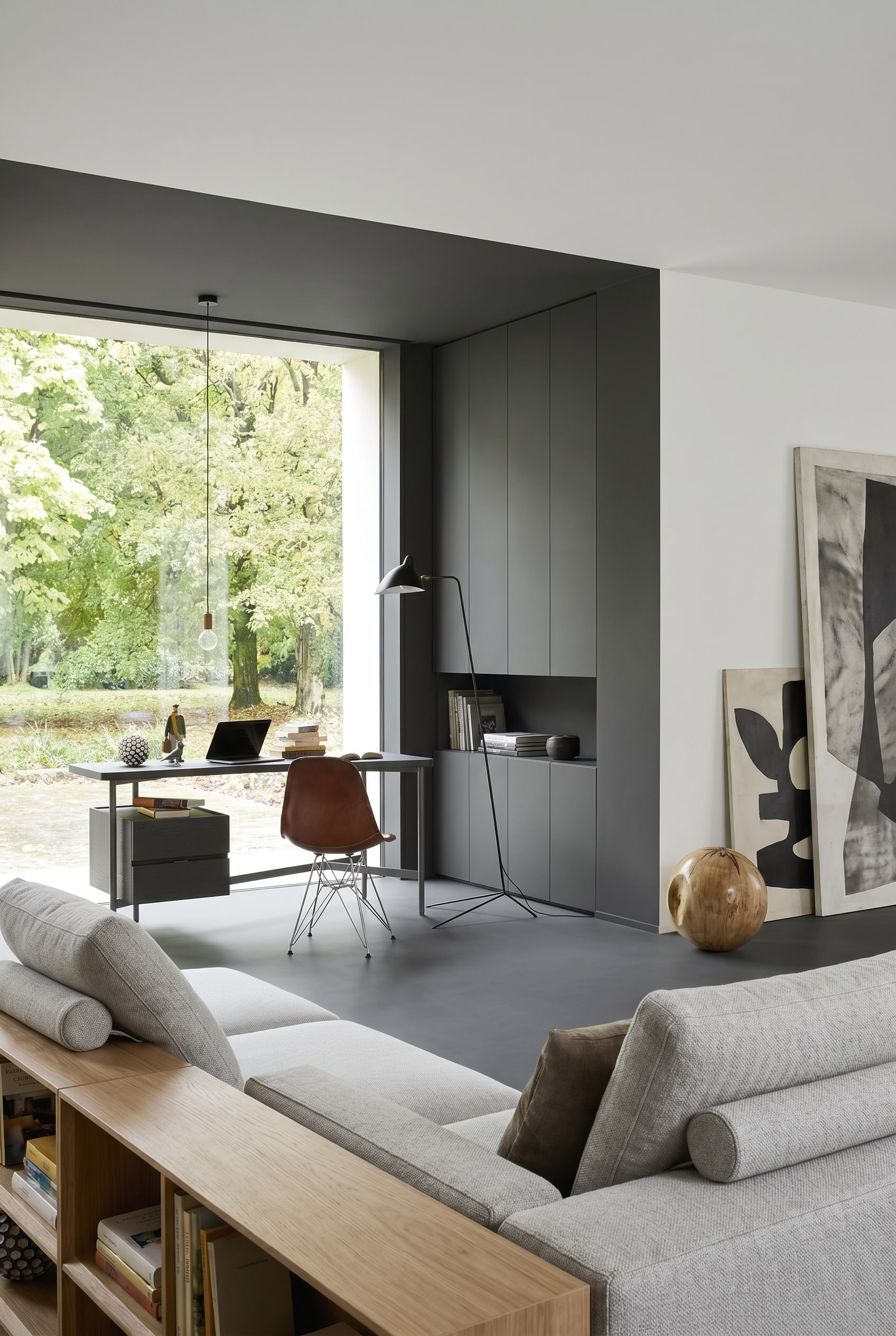 Monochromes Wohnzimmer mit hellgrauem Schreibtisch und braunem Lederstuhl