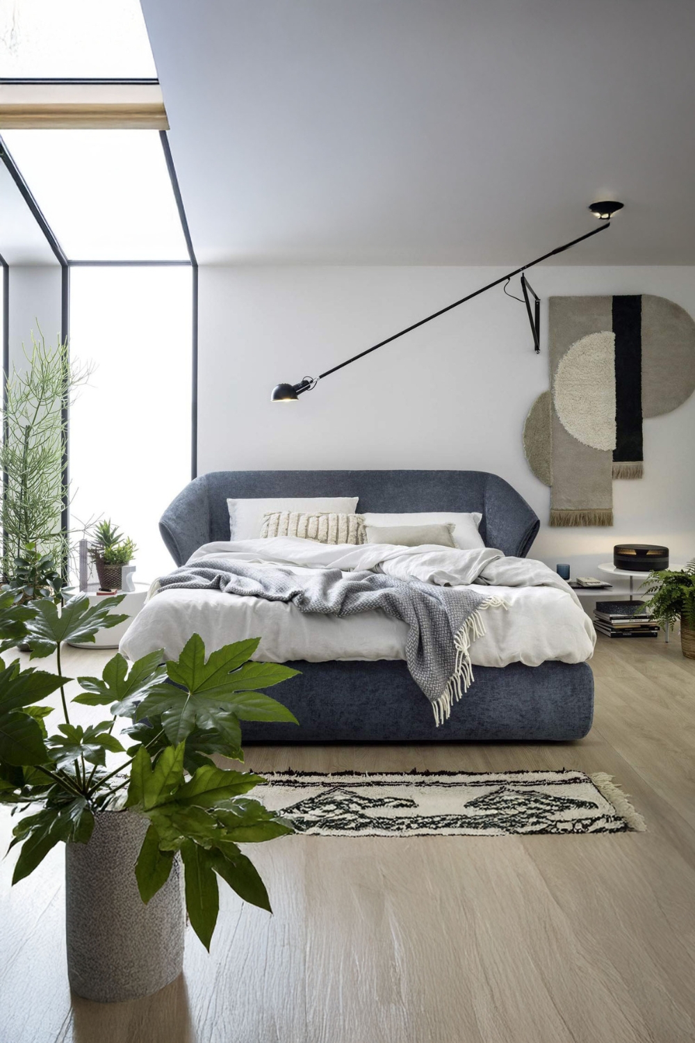 chambre-confortablement-amenagee-avec-un-grand-lit-rembourre-et-plusieurs-plantes