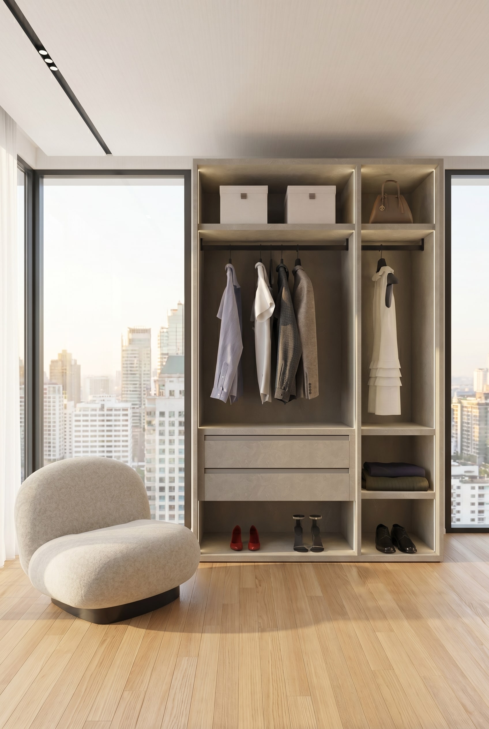 Dressing moderne avec un syst&egrave;me d'armoire ouverte sans cadre en greige structur&eacute;, des chemises en lin suspendues et un fauteuil lounge dans la lumi&egrave;re chaude du matin