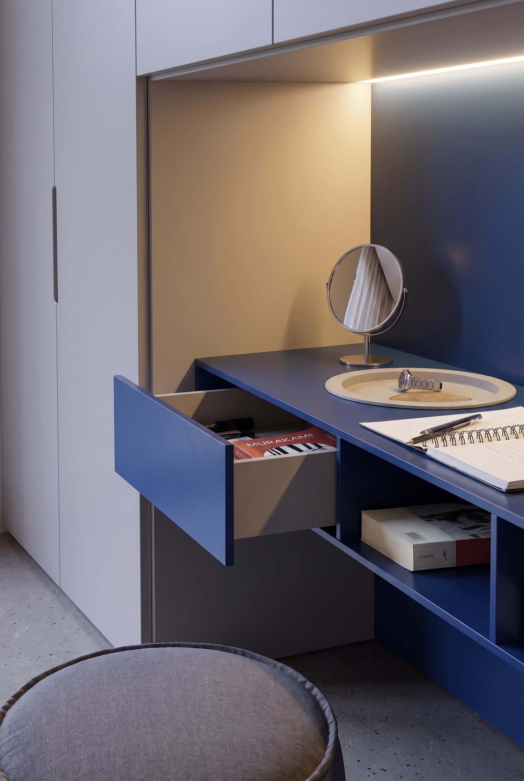 Ge&ouml;ffnete blaue Schublade des Schminktisches mit B&uuml;chern, daneben eine offene Ablage unter der Tischplatte.