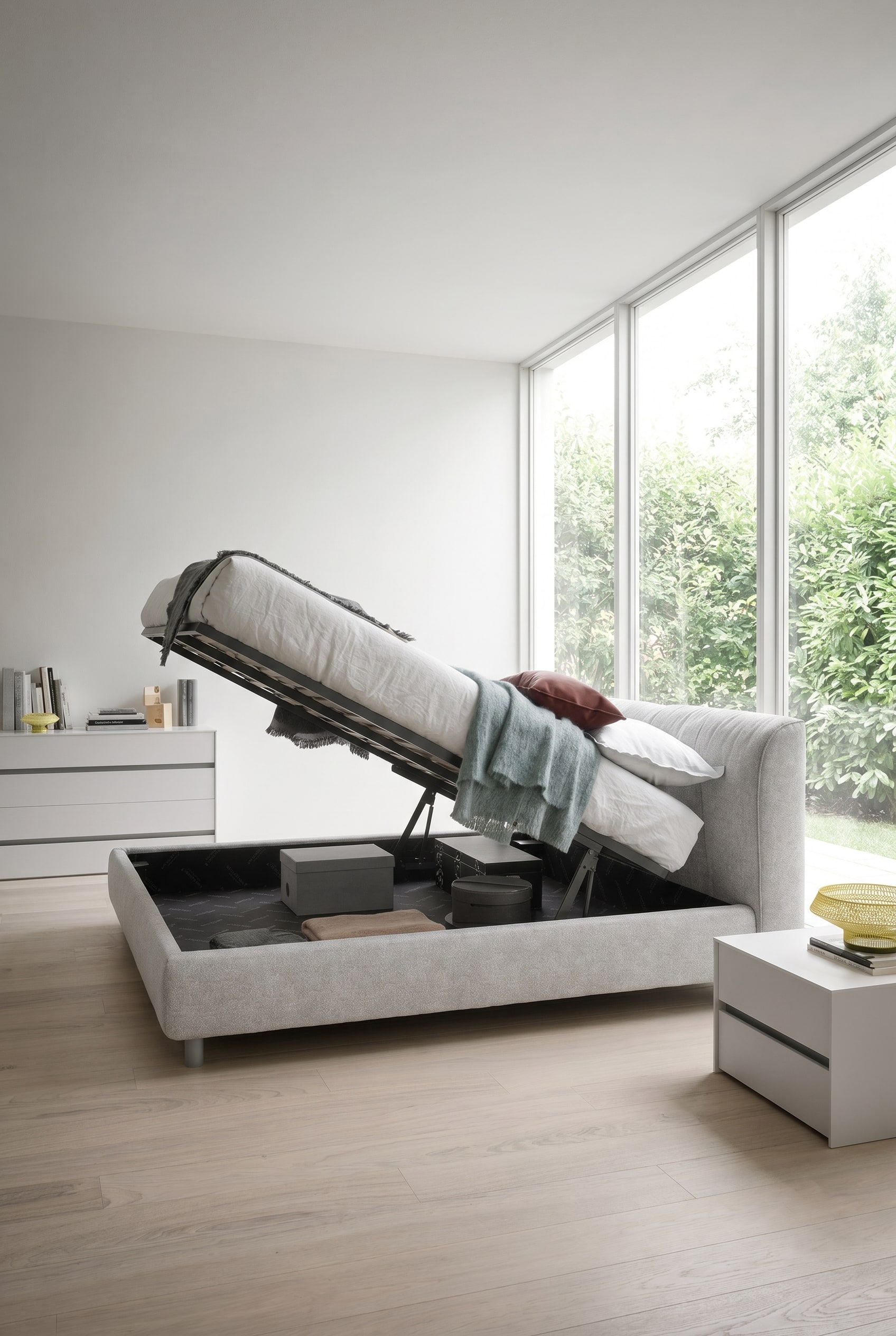 Lit rembourr&eacute; moderne avec coffre de rangement invisible dans une chambre minimaliste