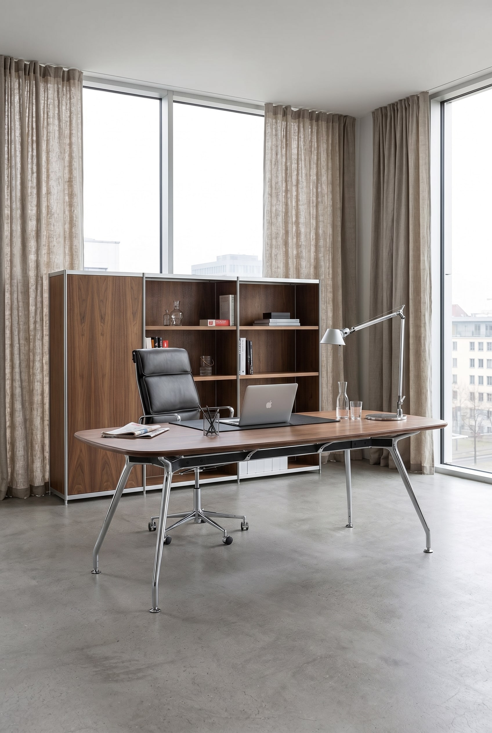 Eleganter Bürotisch mit filigranen Aluminiumbeinen und Walnussplatte im lichtdurchfluteten Executive-Loft vor großen Fenstern