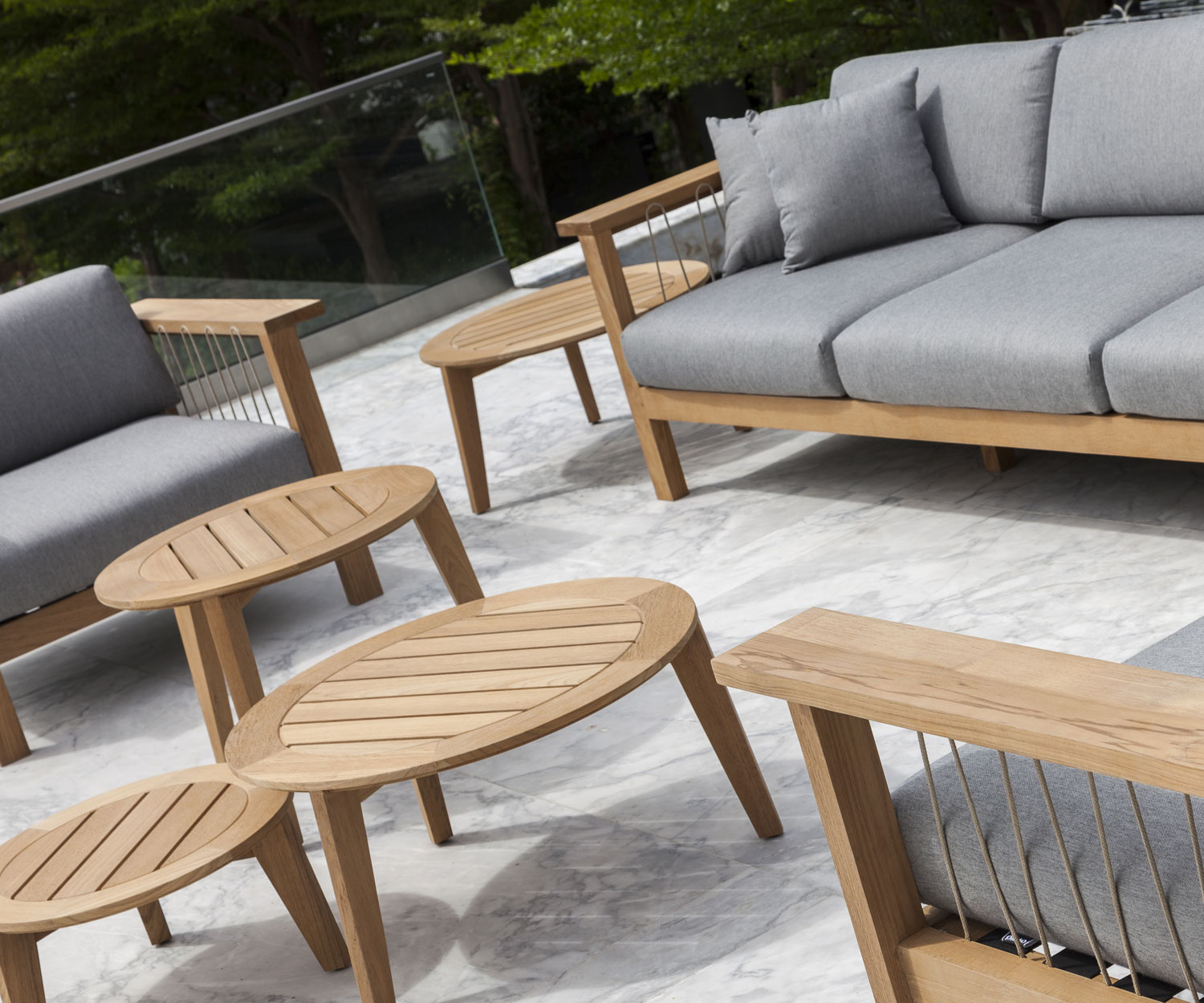 Oasiq Attol Teak Beistelltisch in einer Gruppe inmitten von Gartensofas Oasiq Attol Teak Beistelltisch in einer Gruppe inmitten von Gartensofas