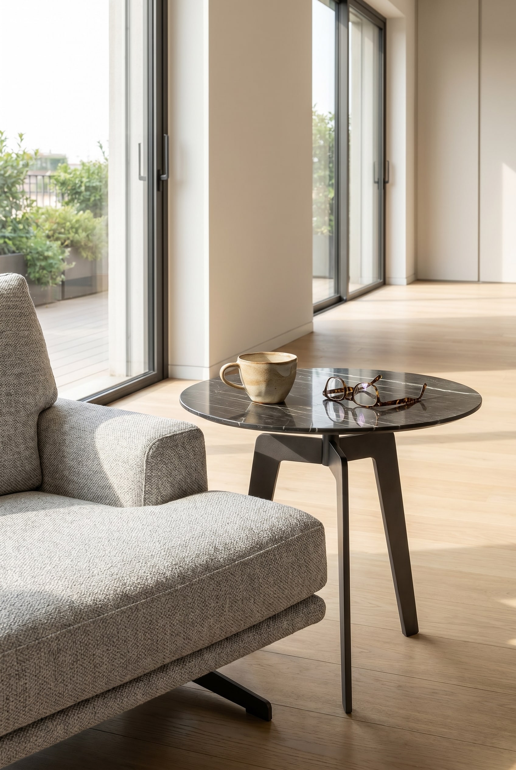 Minimalistischer Lotus Beistelltisch in Marmoroptik neben einem Loungesessel mit einer wei&szlig;en Kaffeetasse