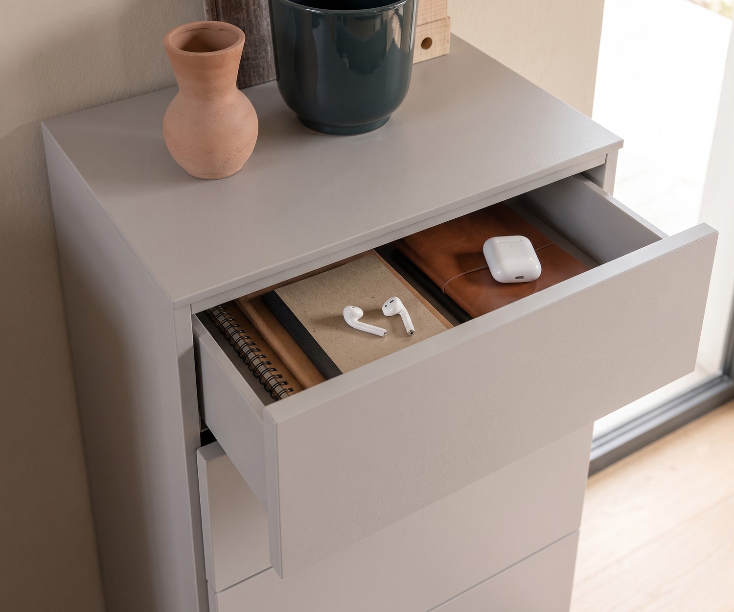 Hochkommode Easy für Schlafzimmer mit geöffneter Schublade für Utensilien, in mattem Beige, moderner minimalistischer Stil.