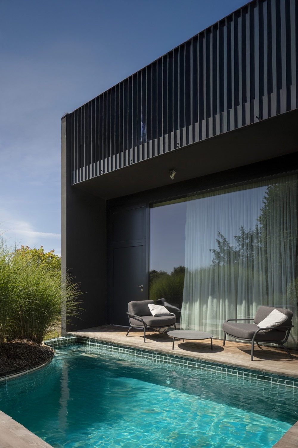 fauteuils-rembourr&eacute;s-larges-modernes-avec-table-derri&egrave;re-une-piscine