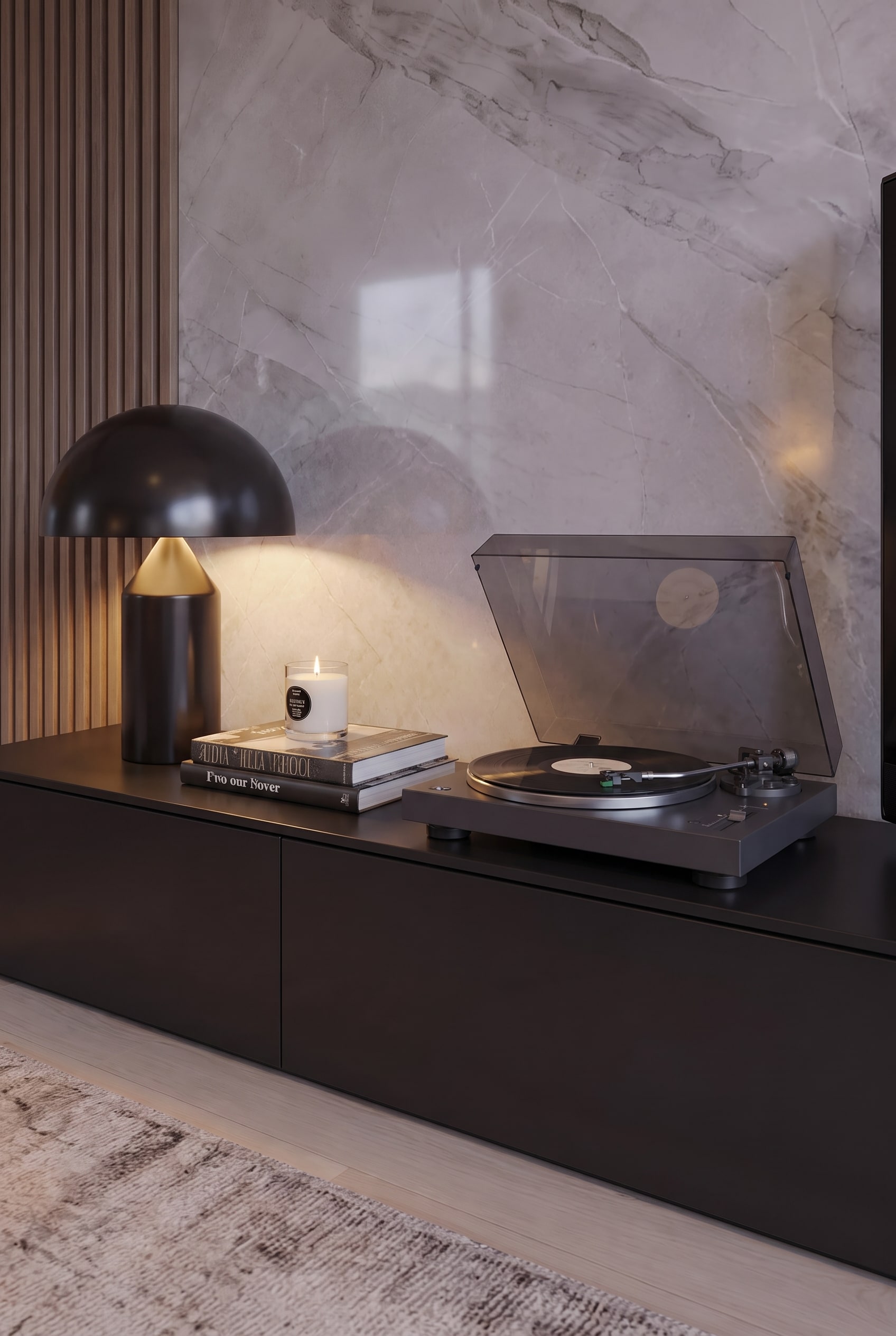 Platine vinyle moderne et bougie allum&eacute;e sur des livres d'art, d&eacute;cor&eacute;es sur un meuble bas mat devant du marbre clair.