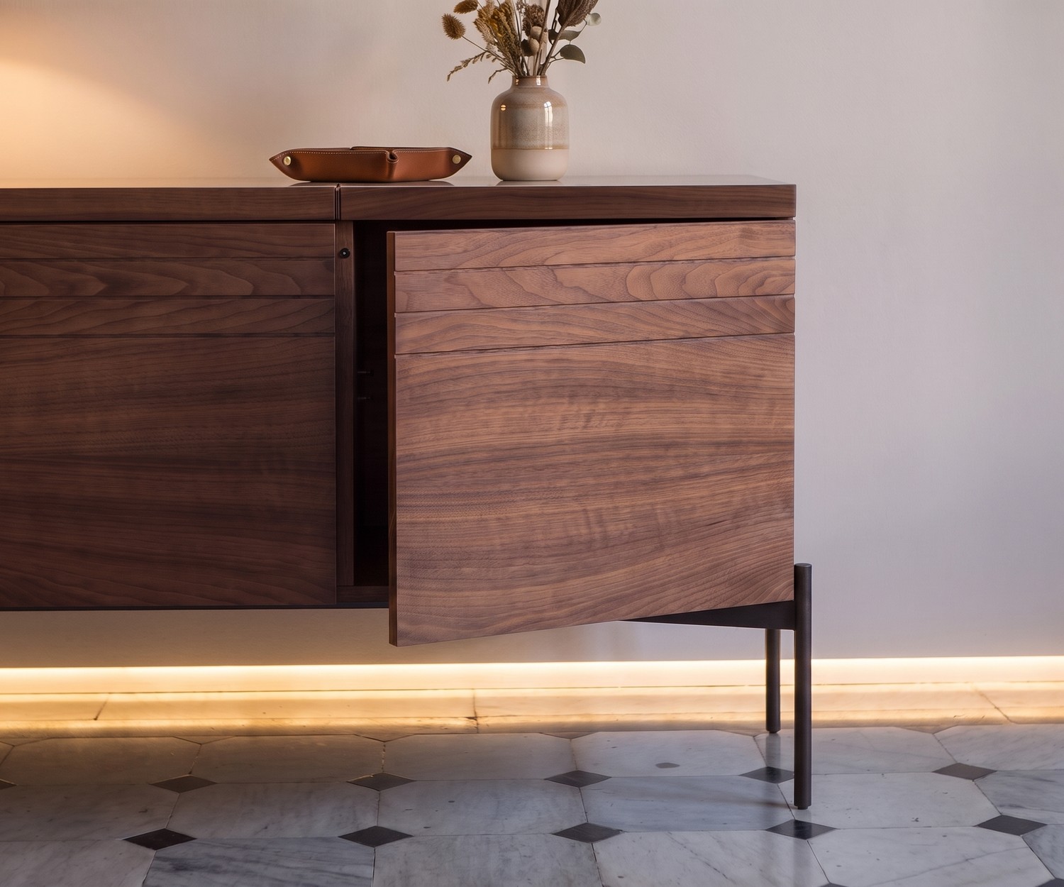Buffet design al2 o-rizon 003 en bois de noyer avec porte push-pull entrouverte pour un salon moderne.