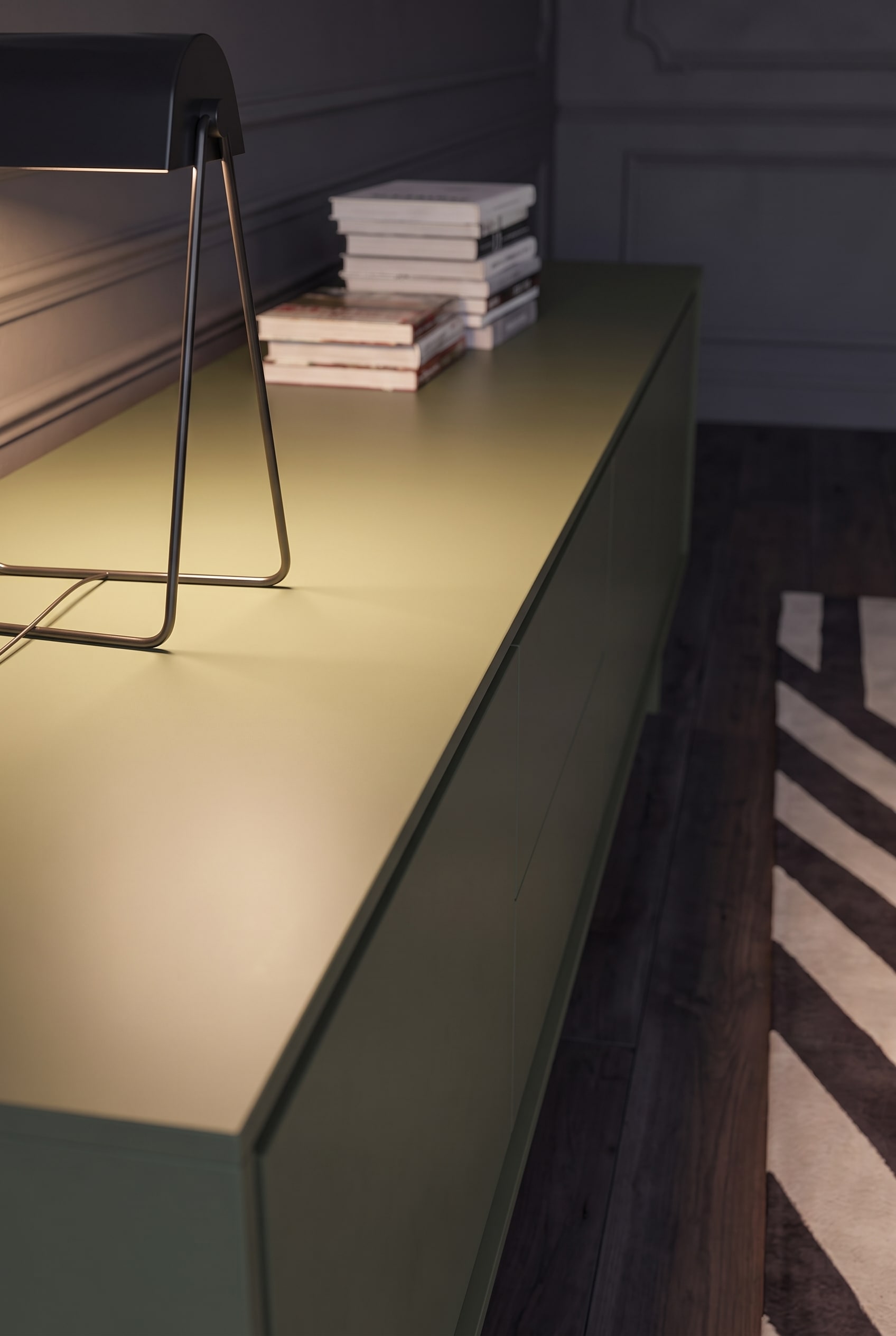 Makroaufnahme der glatten, matt lackierten Abdeckplatte eines olivgrünen Sideboards.