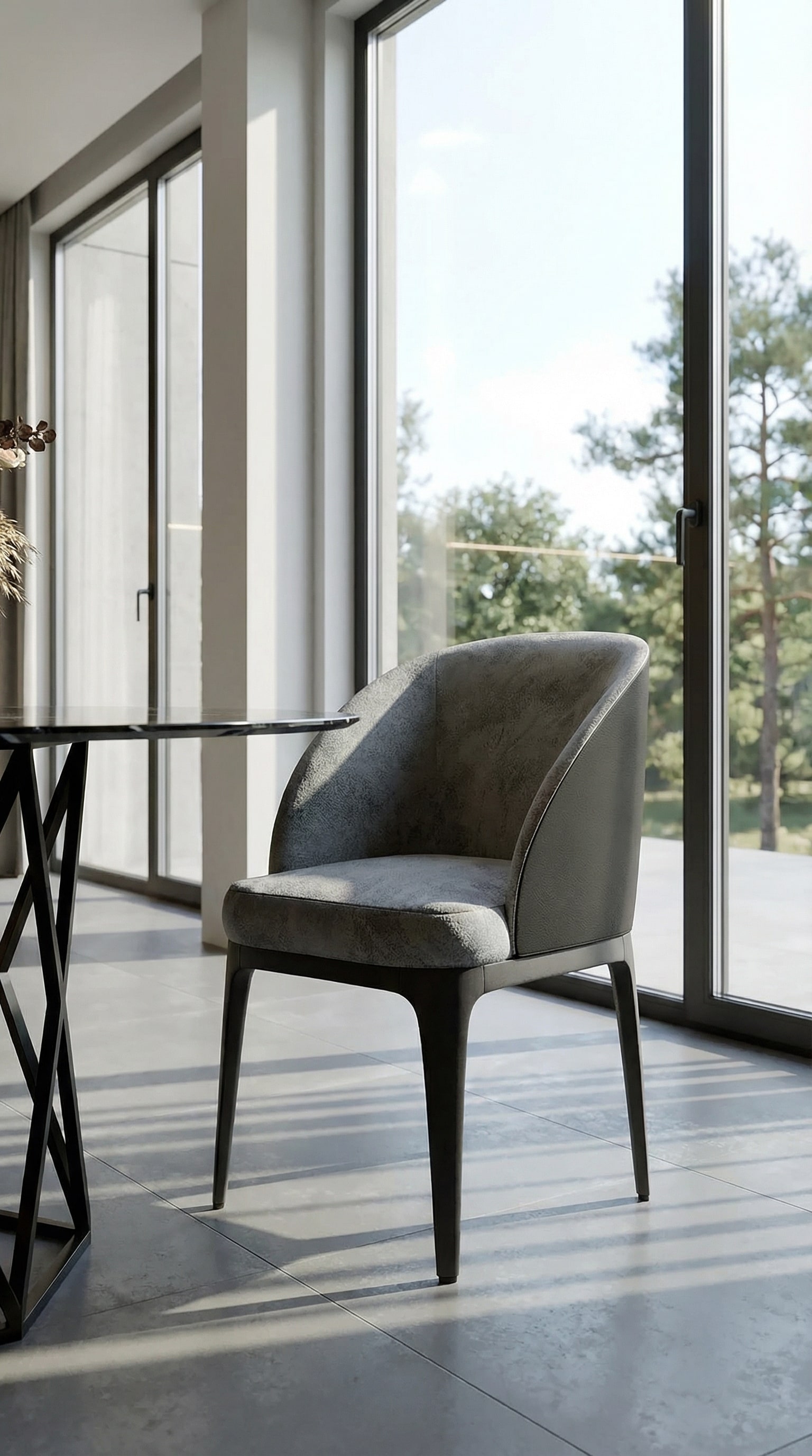 Minimalistischer grauer Armlehnenstuhl an einem eleganten schwarzen Marmortisch im modernen Essbereich Minimalistischer grauer Armlehnenstuhl an einem eleganten schwarzen Marmortisch im modernen Essbereich