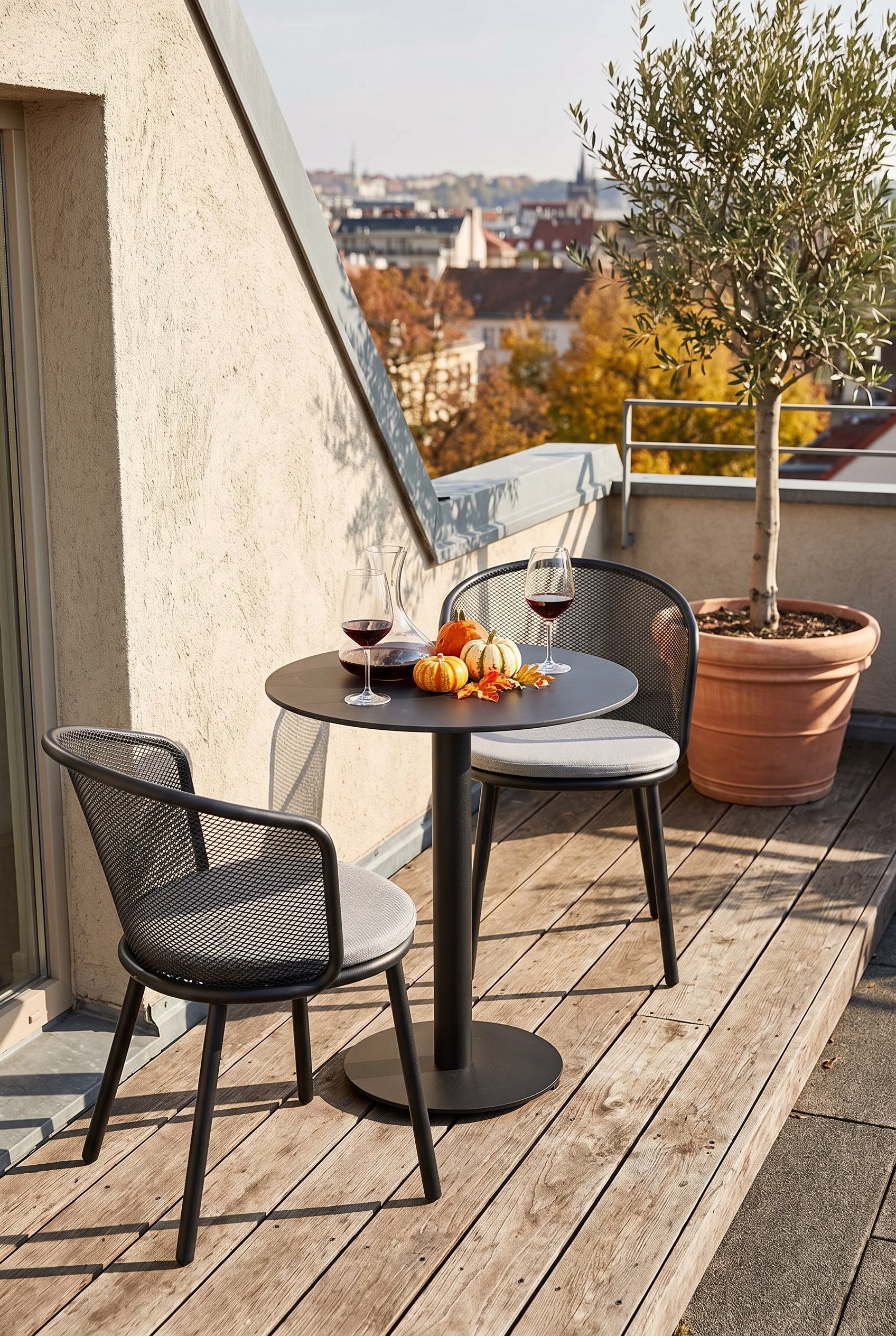 Table de bistrot ronde noire avec pied central &eacute;lanc&eacute; sur une &eacute;troite terrasse de toit en bois