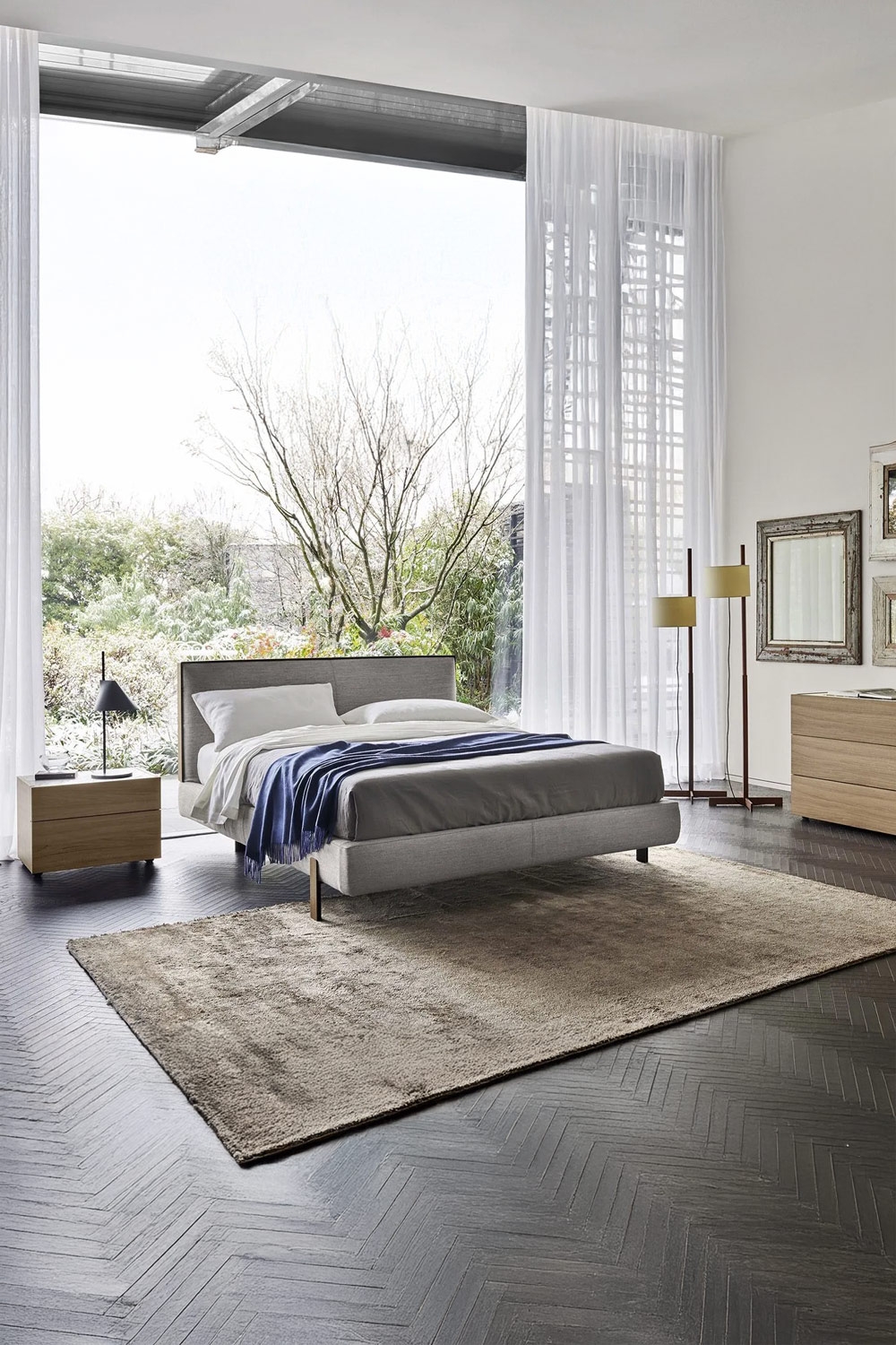 lit-a-cadre-mince-avec-effet-flottant-et-table-de-chevet-sans-poignee-devant-une-grande-fenetre