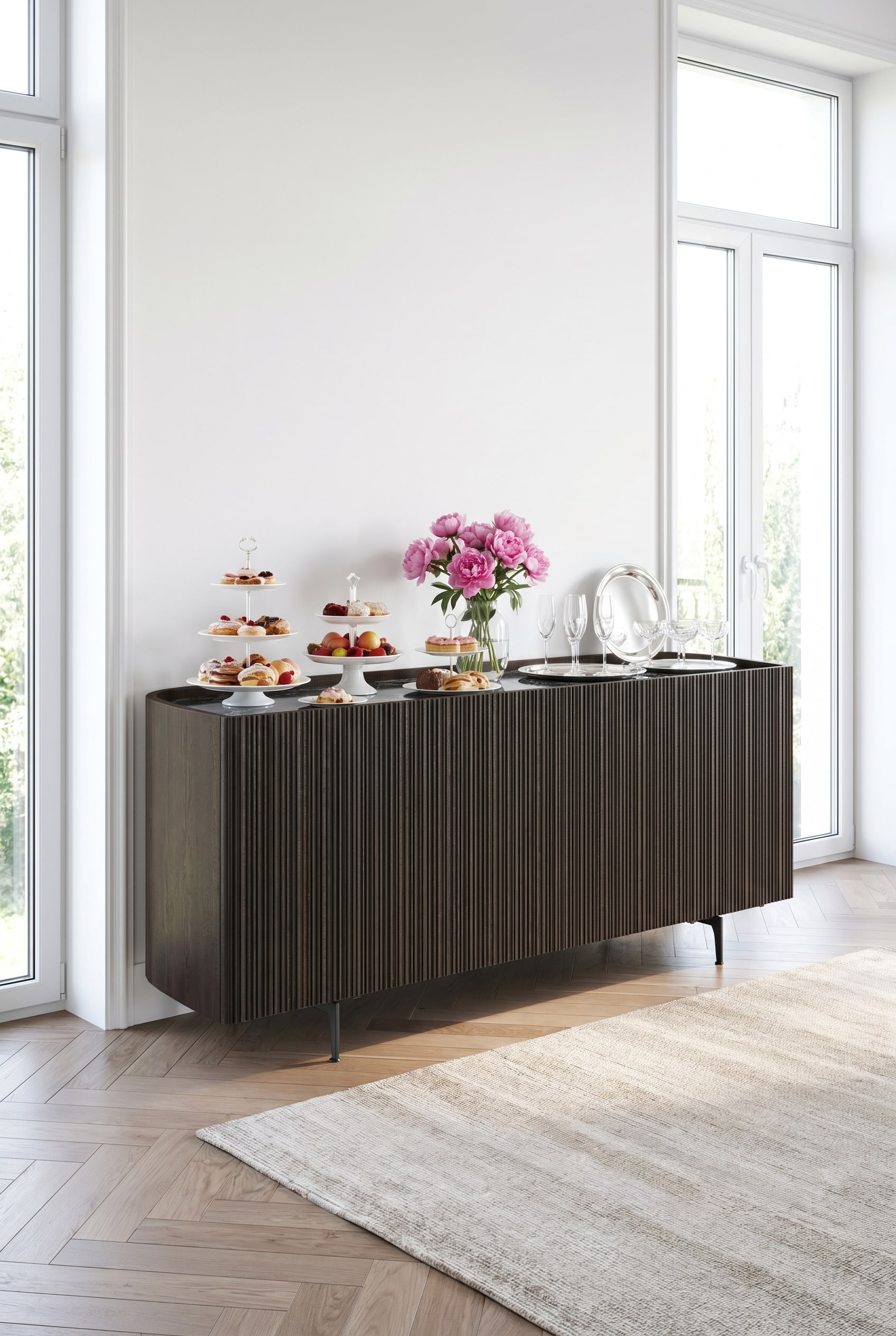 Sideboard Novamobili Bay fonc&eacute; avec coins arrondis et fa&ccedil;ade cannel&eacute;e dans une pi&egrave;ce lumineuse, d&eacute;cor&eacute; d'assiettes en porcelaine blanche et de pivoines roses.