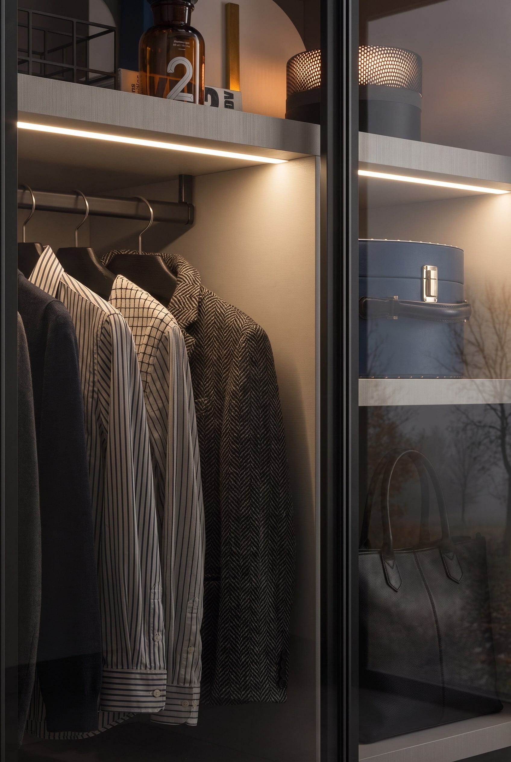 Dressing de haute qualit&eacute; avec fa&ccedil;ades en verre fum&eacute;, o&ugrave; l'&eacute;clairage int&eacute;rieur indirect et les &eacute;tag&egrave;res stables cr&eacute;ent une atmosph&egrave;re de boutique.
