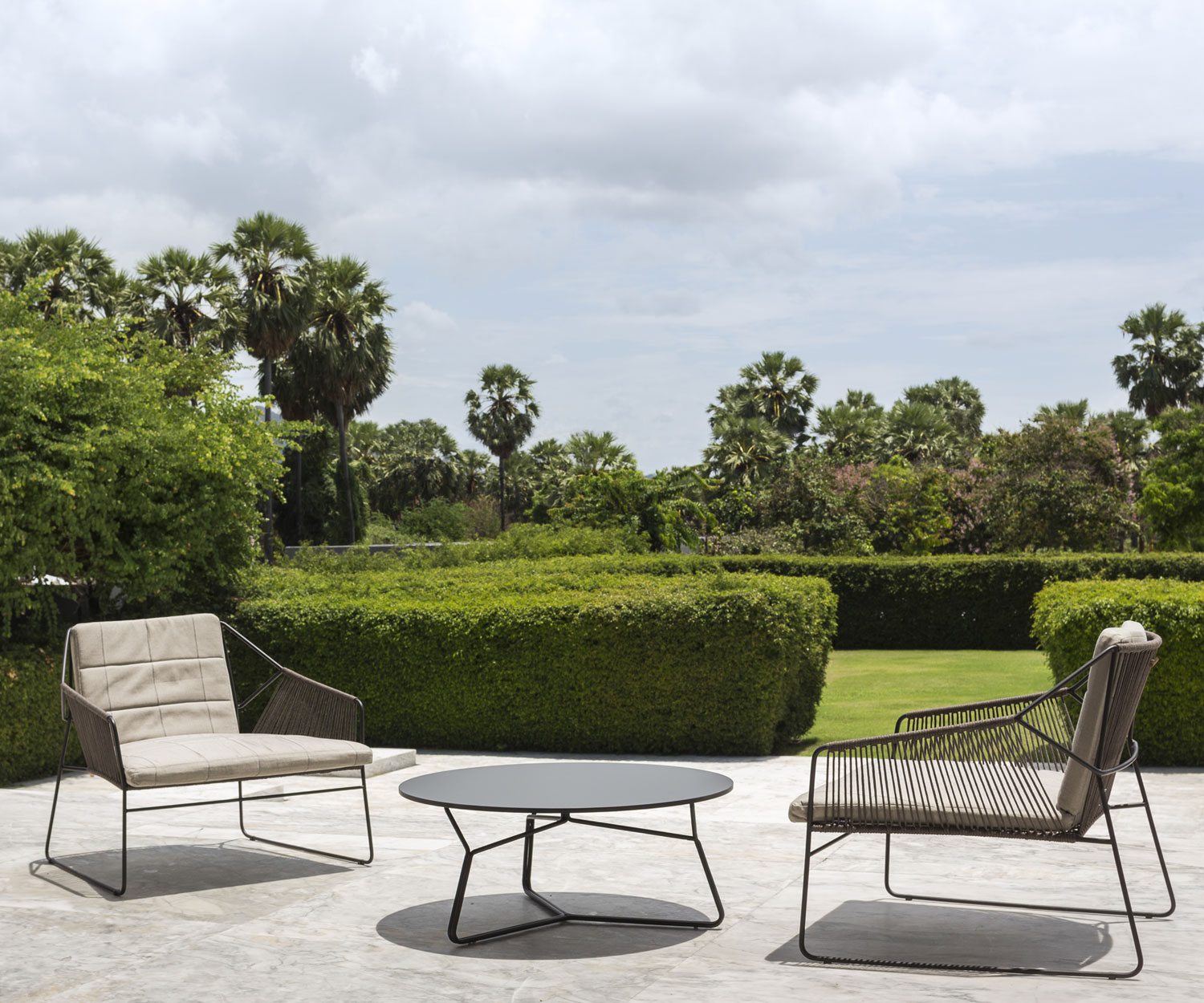 Exklusiver Oasiq Schnur Design Sessel auf der sommerlichen Gartenterasse