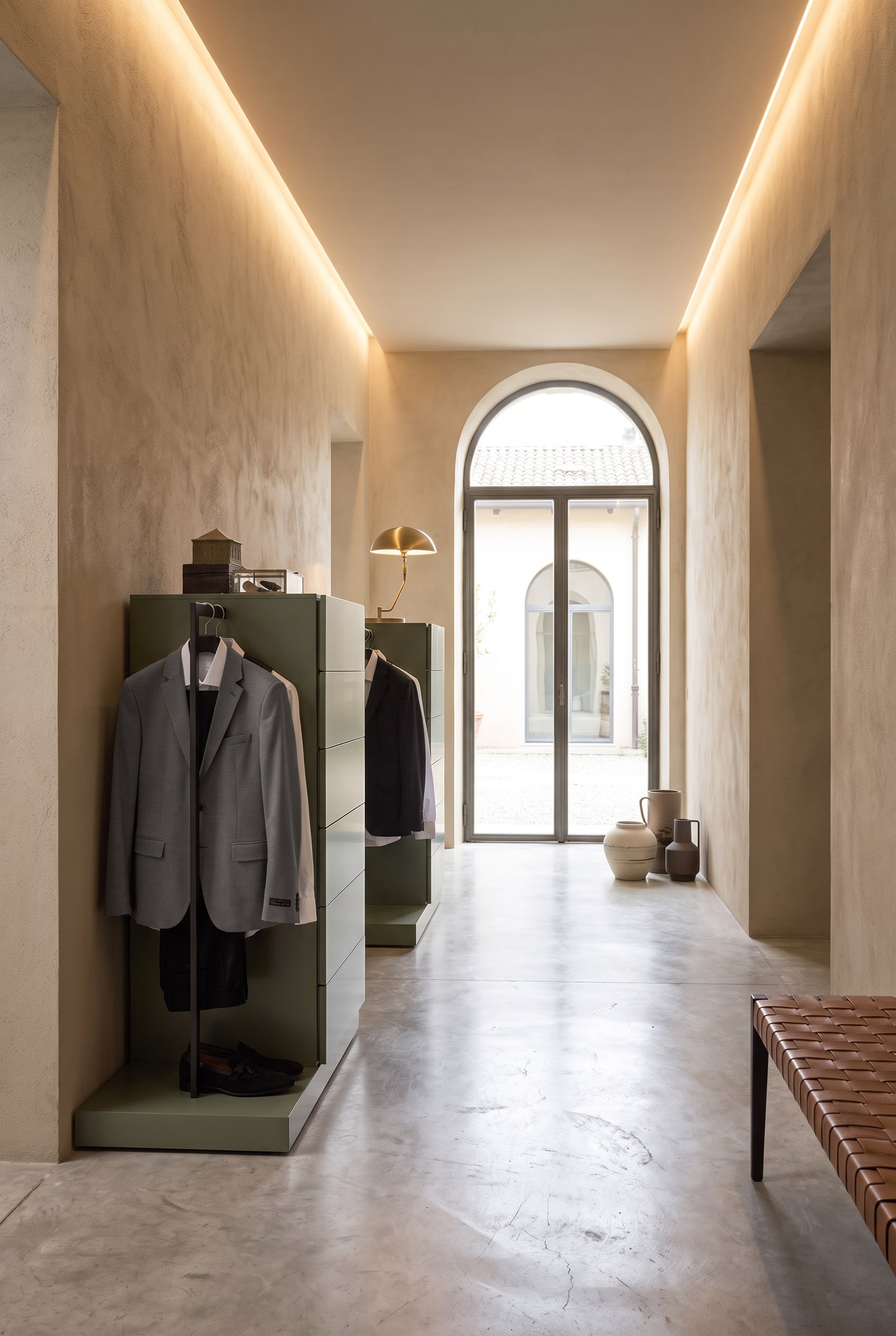 Couloir avec une commode haute verticale, int&eacute;grant lat&eacute;ralement une tringle &agrave; v&ecirc;tements noire en m&eacute;tal avec des vestes suspendues