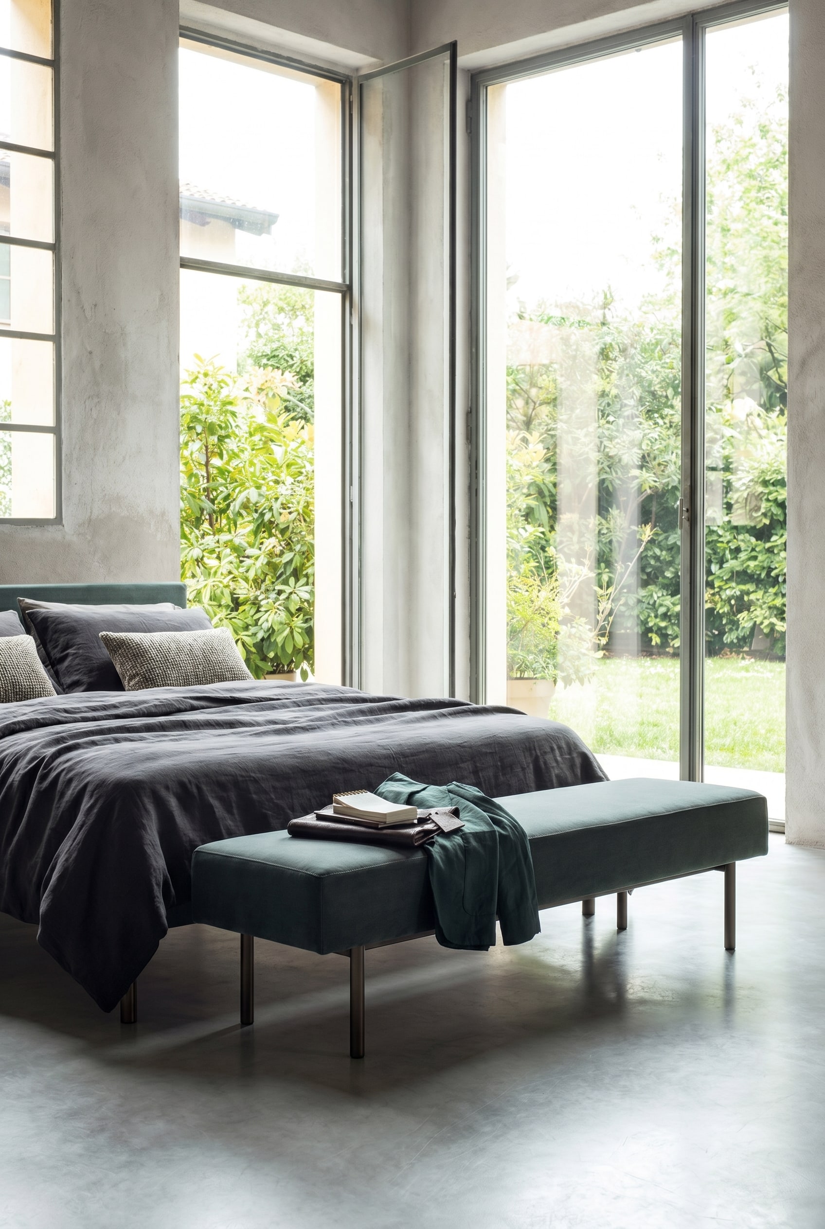 Elegante minimalistische Polsterbank mit schlanken Beinen am Bettende eines modernen Schlafzimmers Elegante minimalistische Polsterbank mit schlanken Beinen am Bettende eines modernen Schlafzimmers