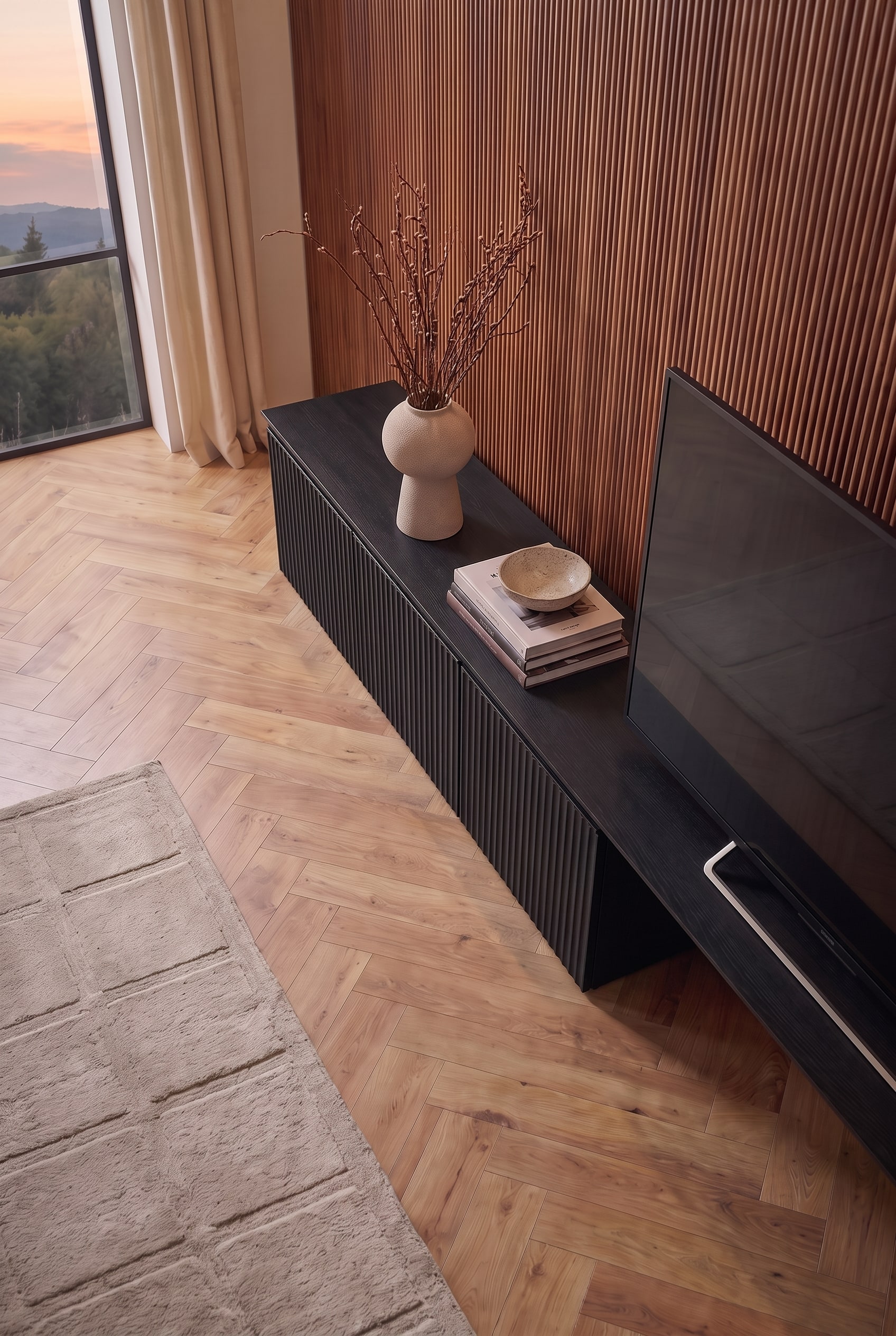 Schräge Aufsicht auf das schwarze TV-Lowboard. Bücher, eine Schale und eine Vase lockern die Fläche neben dem Bildschirm auf.