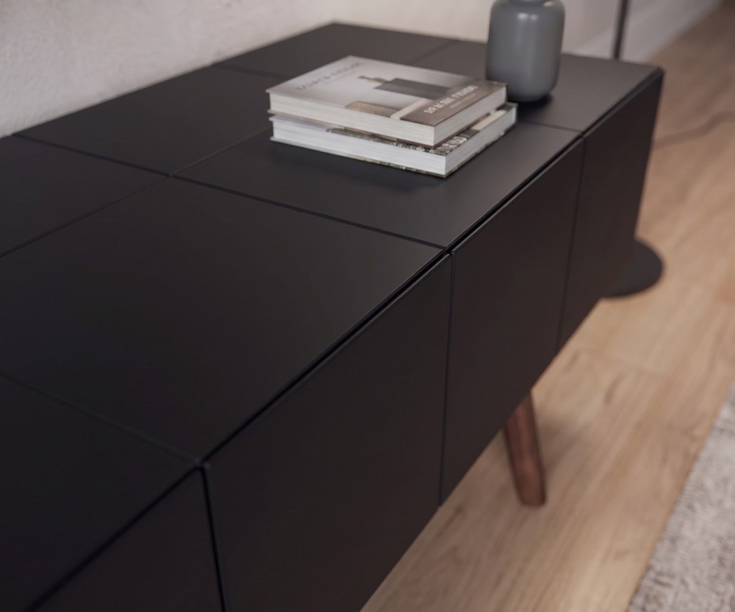 Meuble TV bas al2 MOS-I-KO 005 B noir mat, gros plan sur la façade sans poignée et les pieds en bois de style rétro.