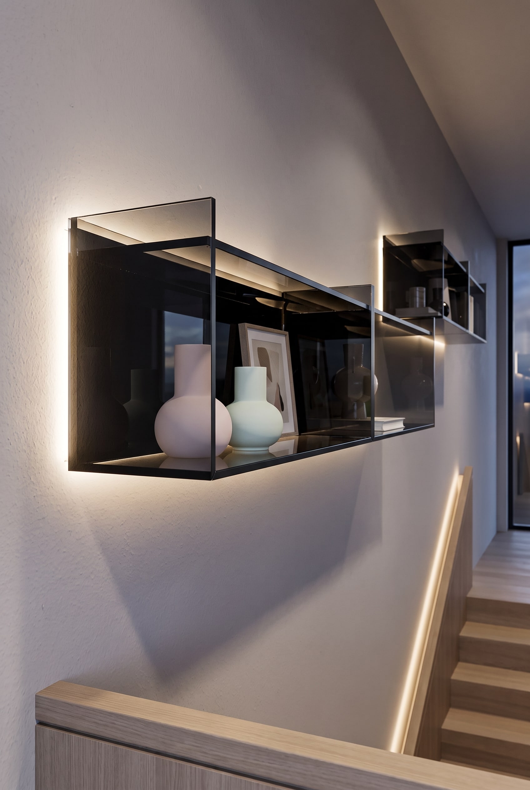 &Eacute;tag&egrave;re en verre flottante sur un mur sombre dans l'escalier, garnie de vases clairs et d'objets d'art