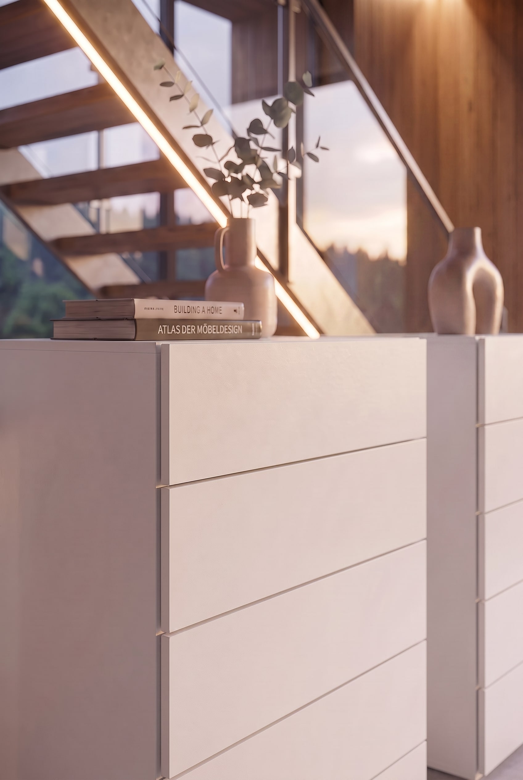 D&eacute;tail d'une commode blanche avec des livres de design et un vase en c&eacute;ramique sous la lumi&egrave;re chaude du soleil.