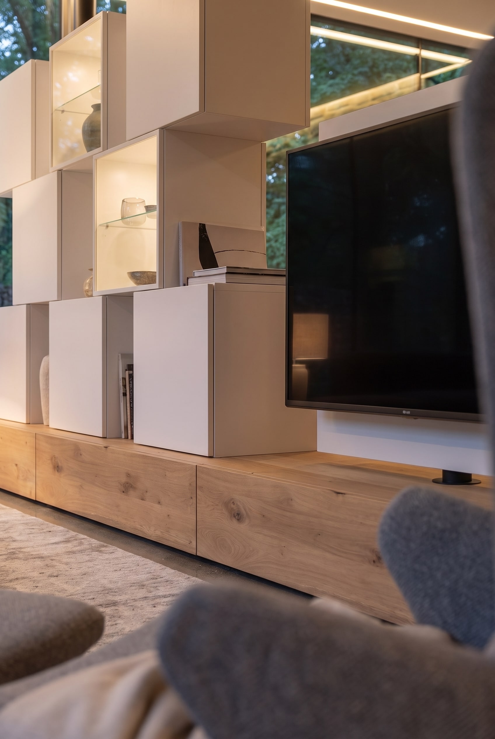 Freistehende Medienwand aus warmem Eichenholz mit integriertem Fernseher und unsichtbarer Kabelf&uuml;hrung im offenen Wohnzimmer