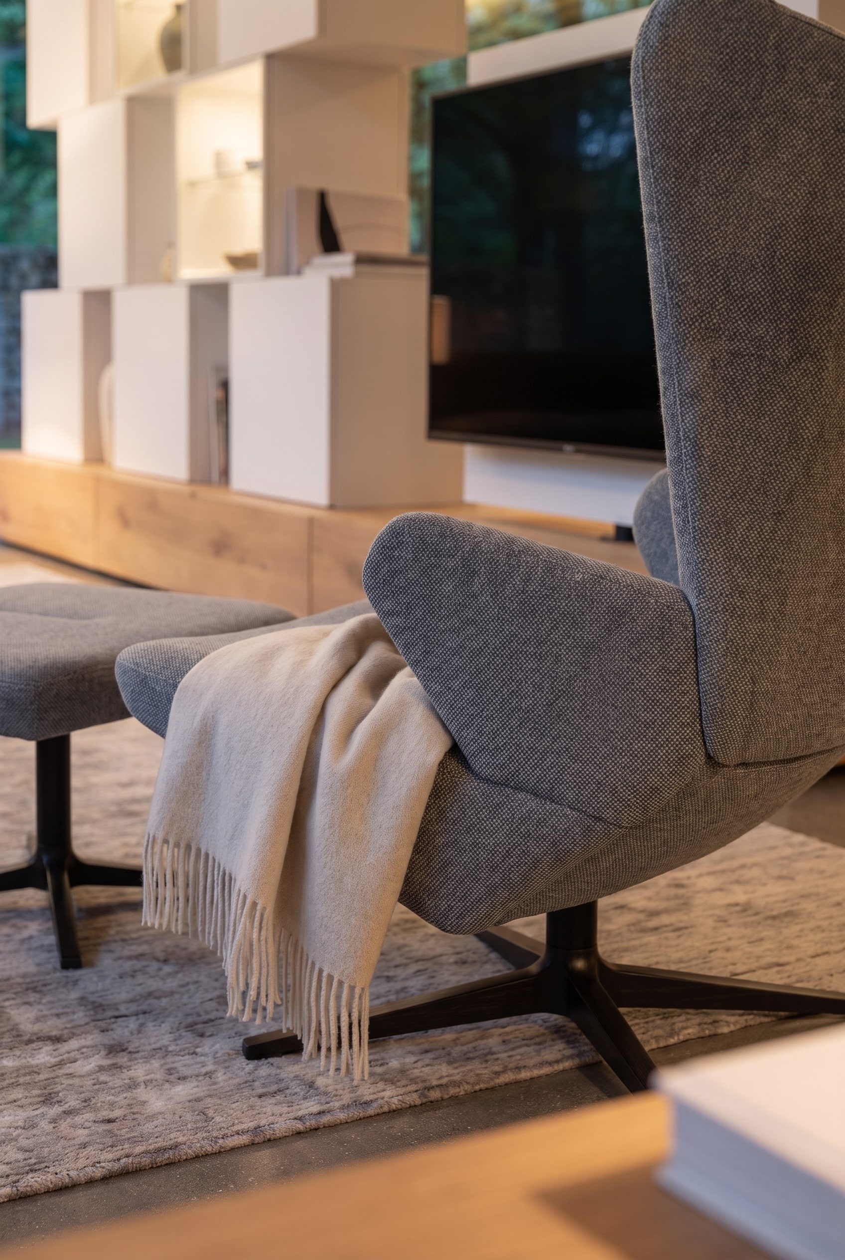 Ein moderner Sessel Prostoria Trifidae steht gem&uuml;tlich neben einem eleganten Raumteiler im Wohnzimmer