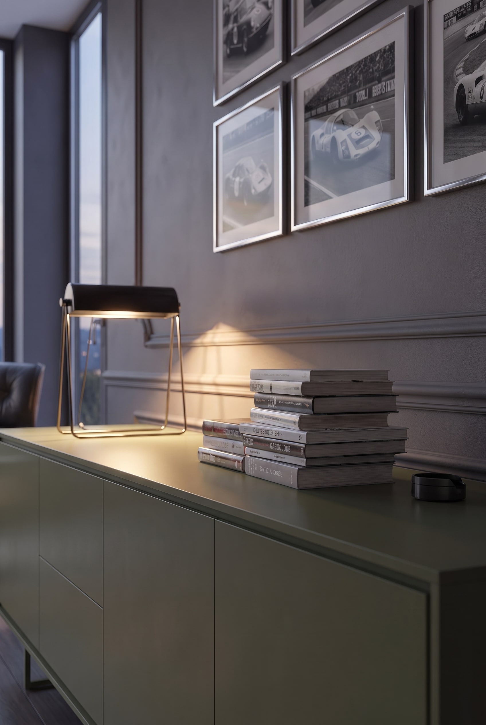 Nahaufnahme von horizontal gestapelten B&uuml;chern und einer modernen Tischleuchte auf einem matten Sideboard.