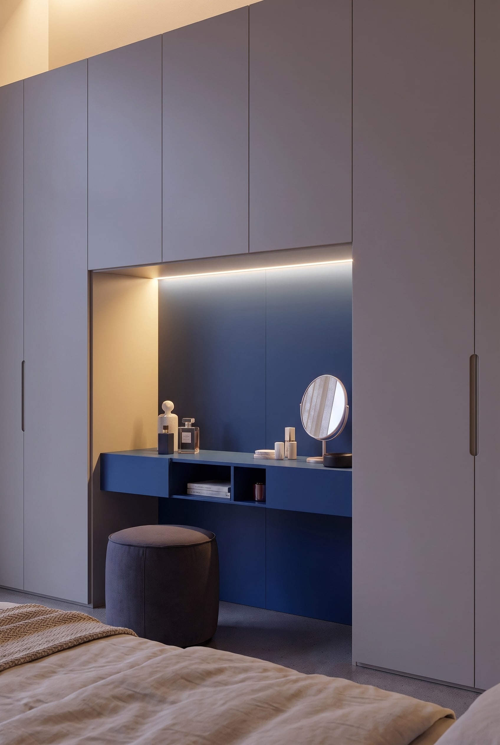 Detailaufnahme der blauen Schranknische mit beleuchtetem Schminktisch, rundem Spiegel und Parfumflakons.