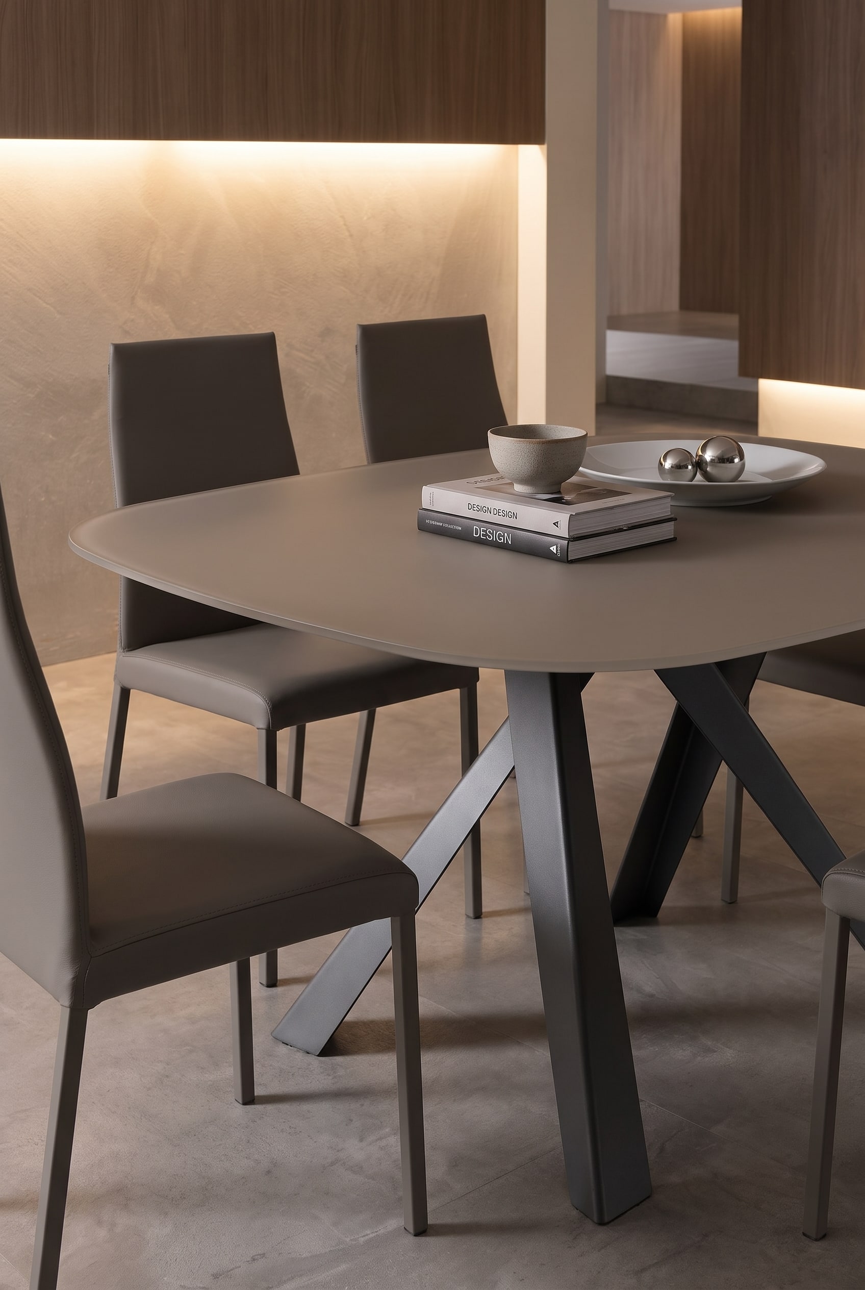 Table &agrave; manger filigrane Ozzio Bombo avec plateau fin r&eacute;sistant aux rayures et chaises de salle &agrave; manger &eacute;l&eacute;gantes dans une lumi&egrave;re chaude