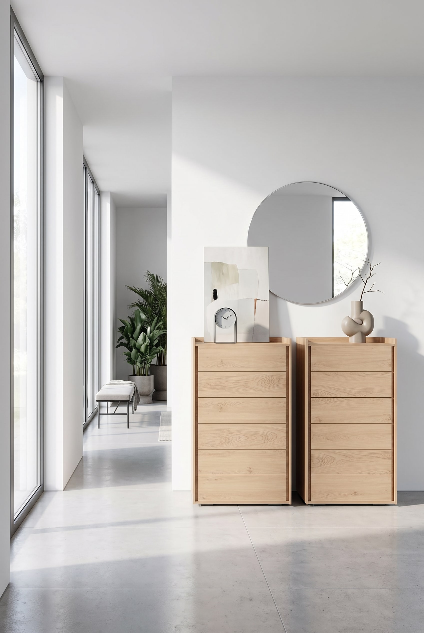 Commode haute &eacute;troite en bois clair dans le couloir, sur le plateau une horloge de table &eacute;l&eacute;gante et un tableau minimaliste appuy&eacute;