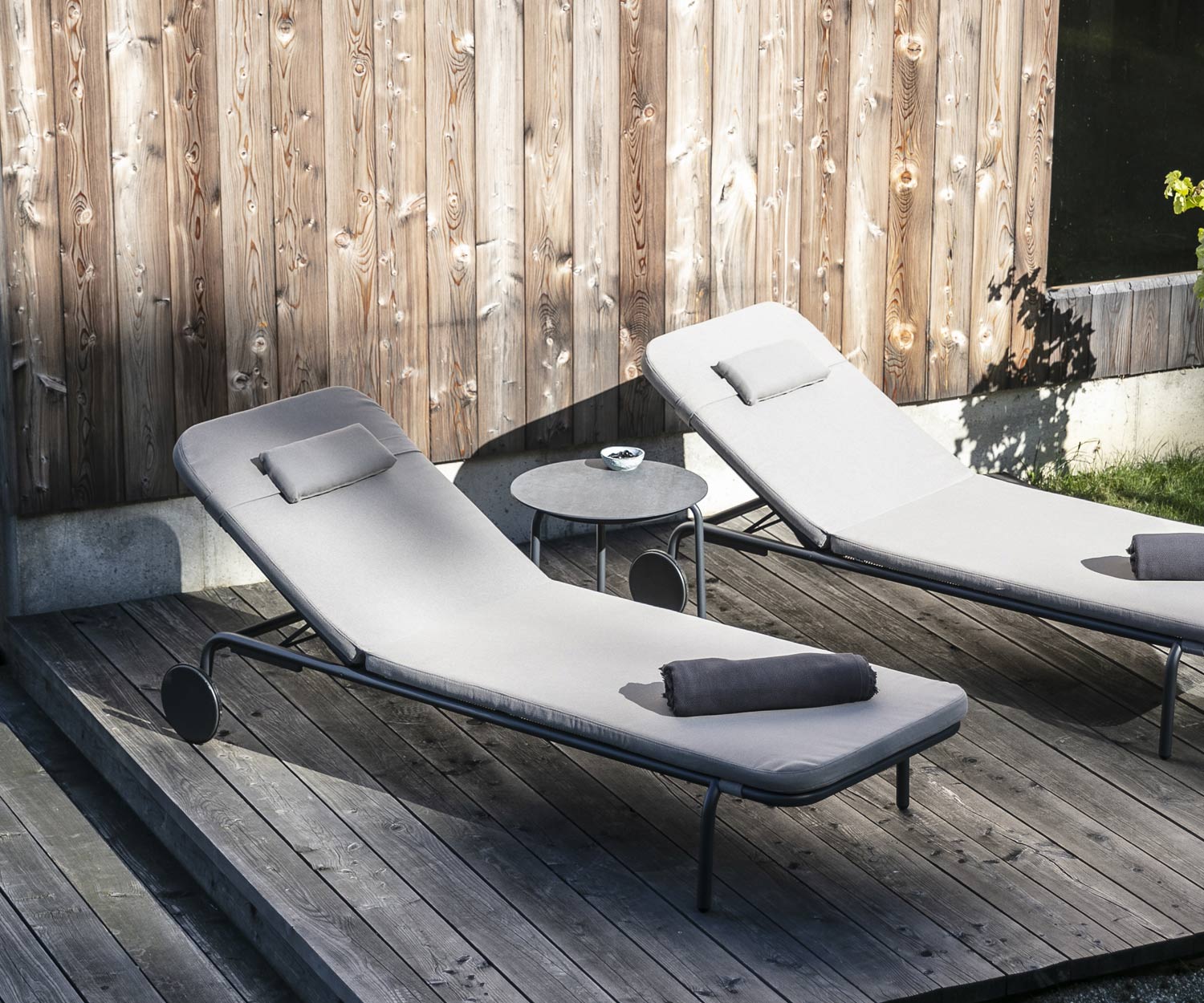 Table d'appoint design Starling de Todus avec deux chaises longues de jardin sur véranda en bois