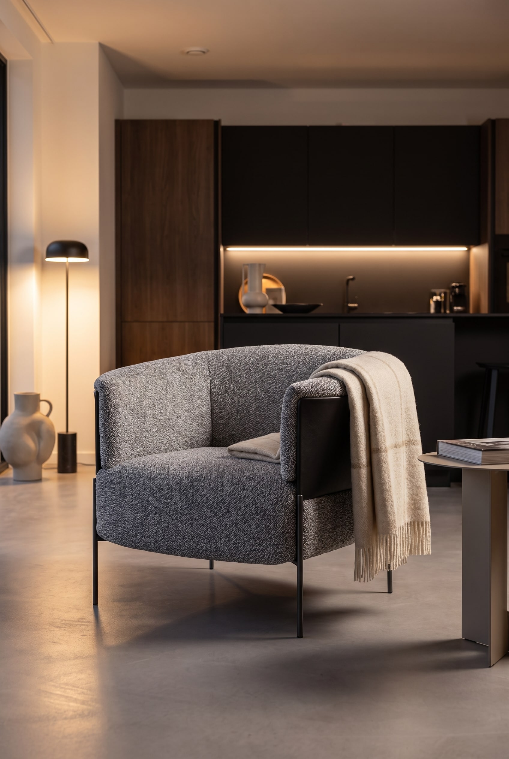 Fauteuil rembourr&eacute; gris clair avec dossier rond comme contraste doux dans la pi&egrave;ce