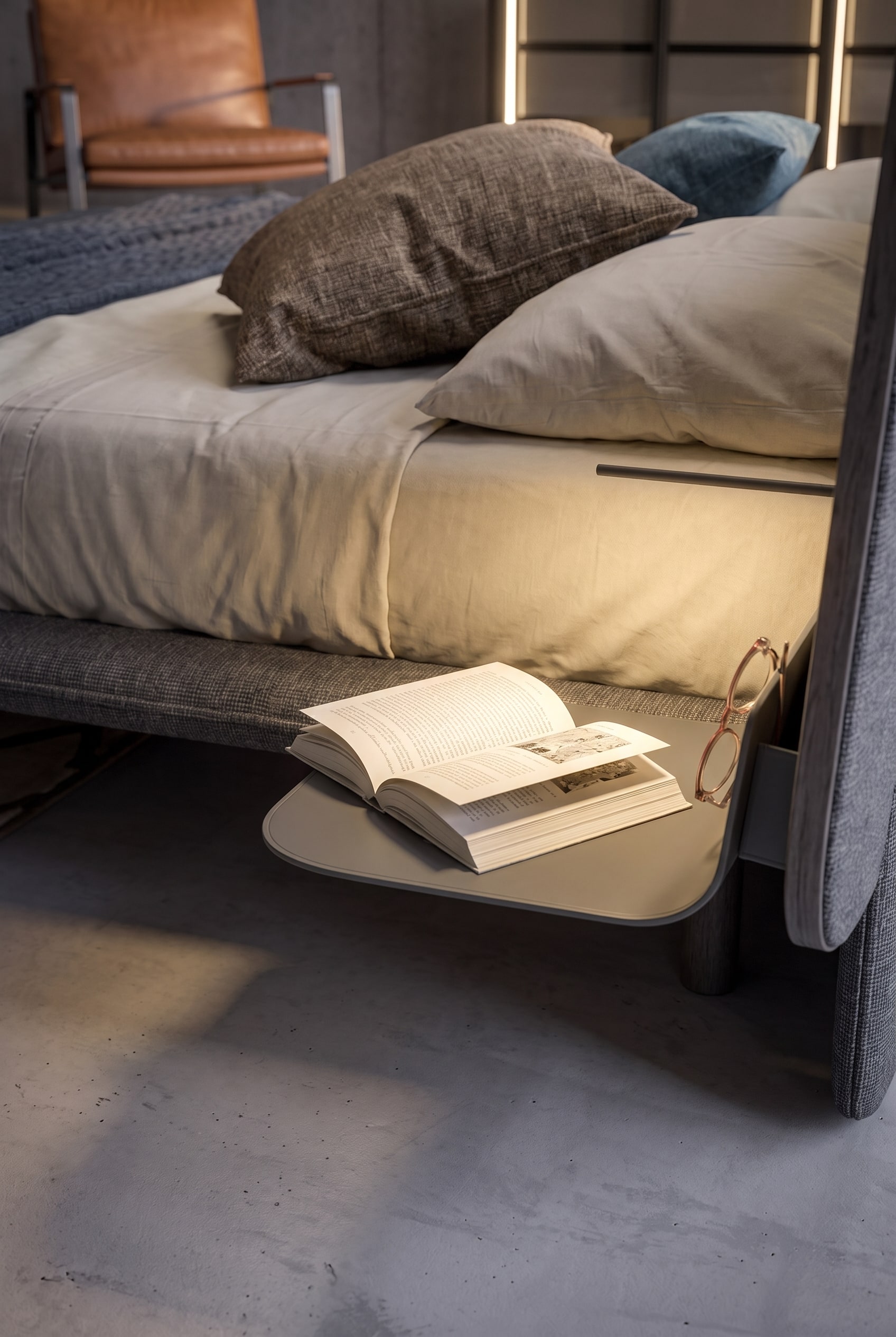 Étagère de chevet flottante en métal, montée sur la tête de lit, avec un livre ouvert et des lunettes.