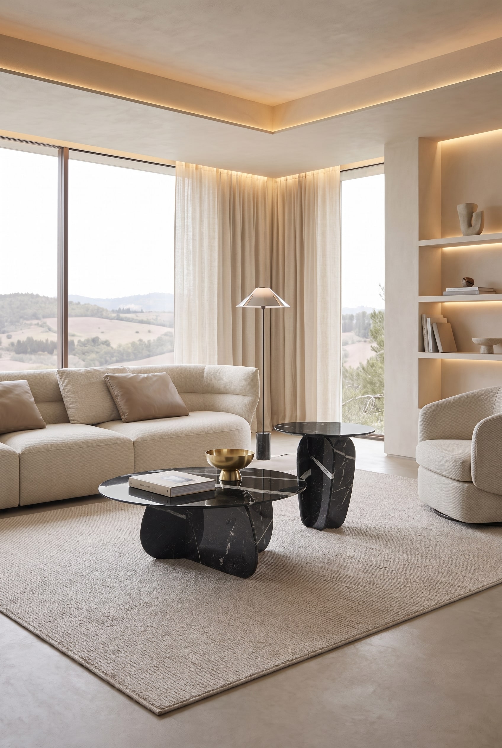 Salon avec deux tables basses de forme organique en marbre foncé sur un tapis clair, en arrière-plan des fenêtres pleine hauteur et un éclairage indirect