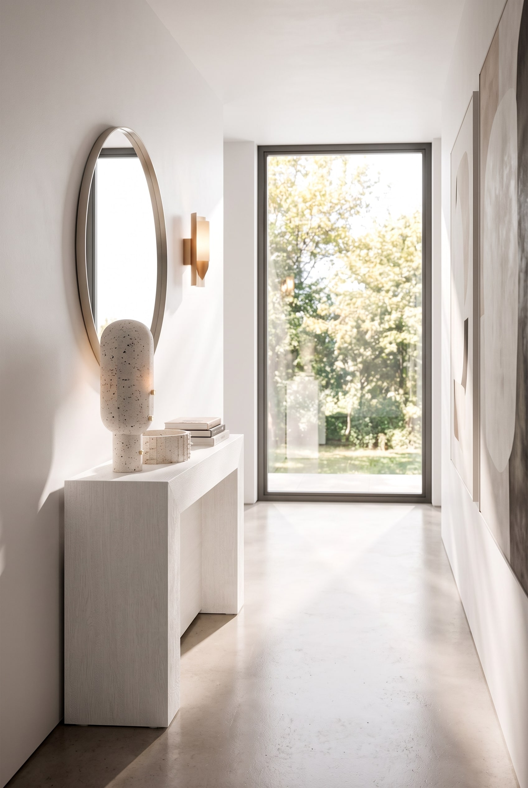 Couloir étroit avec une console blanche ultra-plate, au-dessus, un miroir mural rond et une applique murale minimaliste