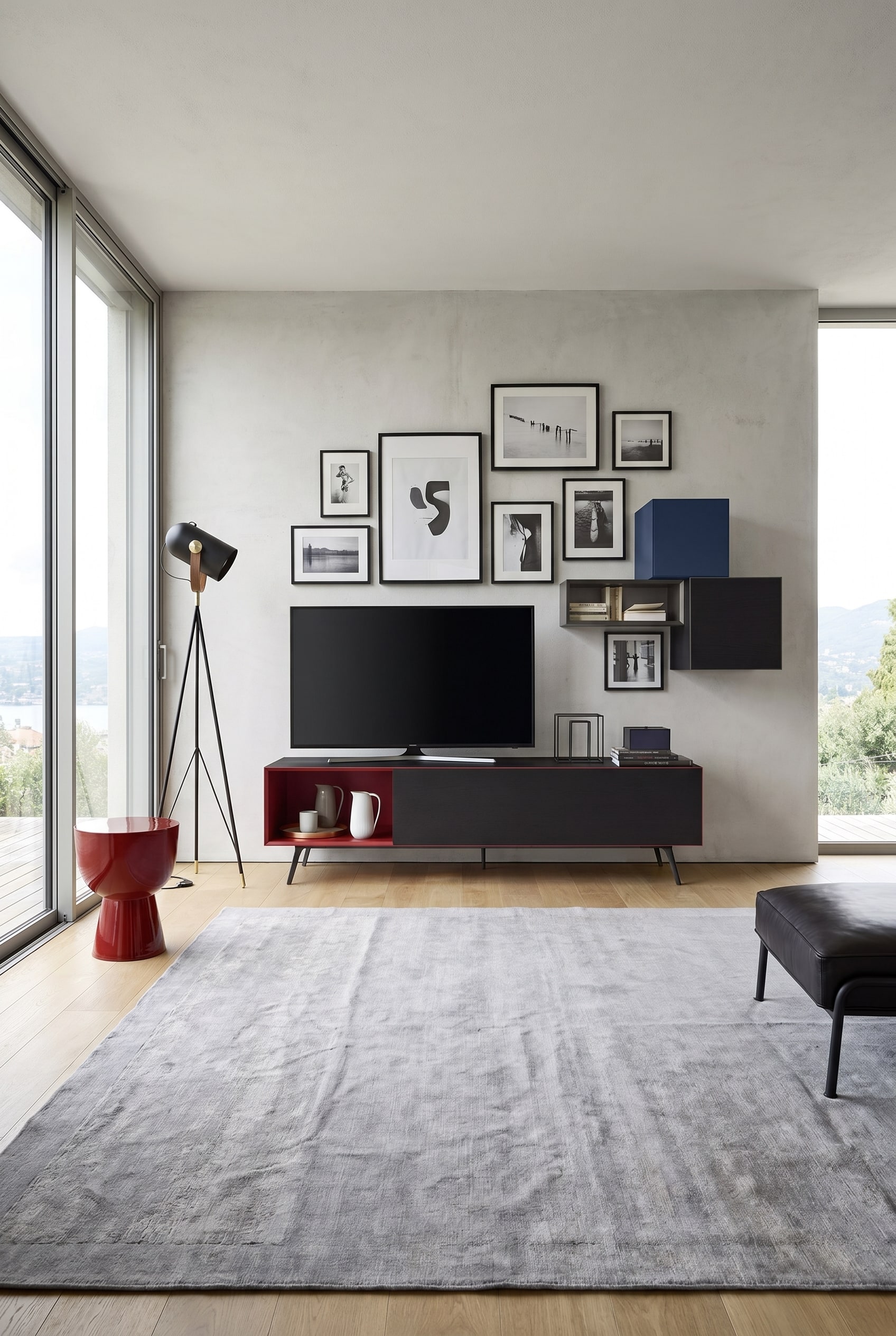 Meuble bas minimaliste avec des compartiments rouges ouverts et des façades noires sous un mur de galerie de salon