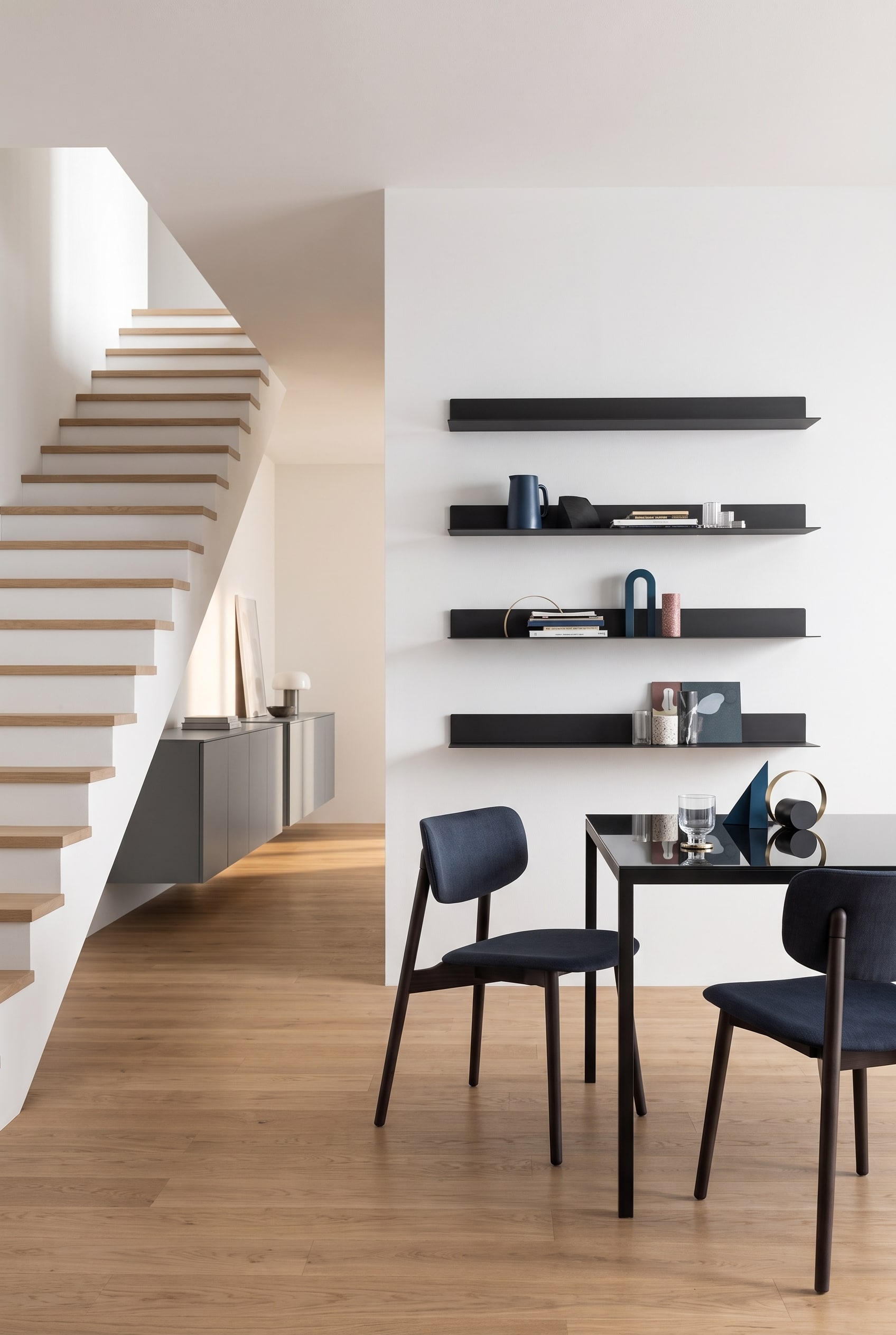 Un &eacute;l&eacute;gant buffet Punt Rio avec fa&ccedil;ades ferm&eacute;es dans le couloir &agrave; c&ocirc;t&eacute; d'un escalier en bois moderne.