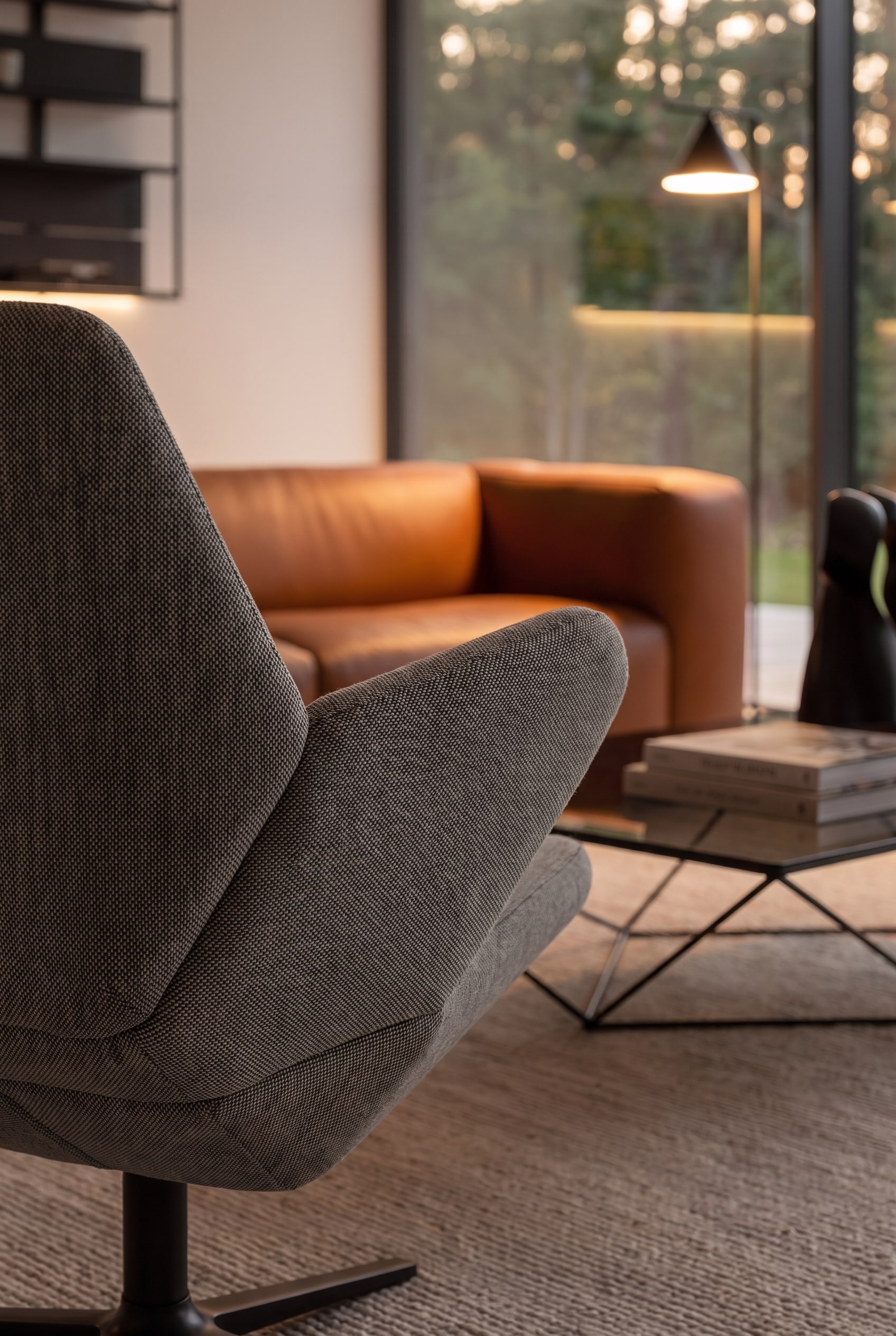 Gros plan de la surface en tissu gris, grossi&egrave;rement structur&eacute; du fauteuil Prostoria Trifidae avec un subtil jeu de lumi&egrave;re.