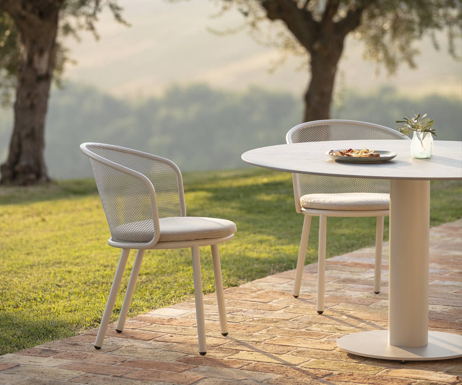 Table de salle à manger Branta Outdoor avec plateau de table en céramique grise dans le jardin