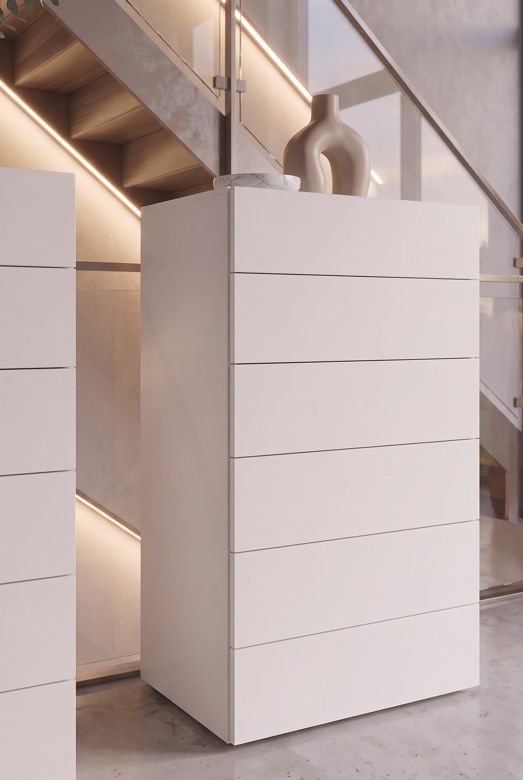 Vue d&eacute;taill&eacute;e d'une commode haute blanche avec tiroirs sans poign&eacute;e et joint d'ombre fin.