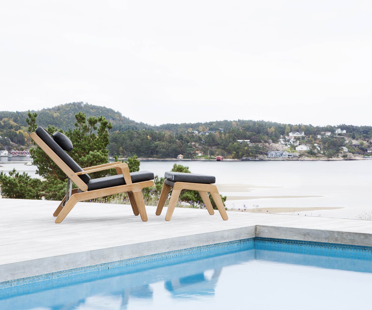 Oasiq Chaise longue Skagen Design en teck avec tabouret Skagen au bord de la piscine