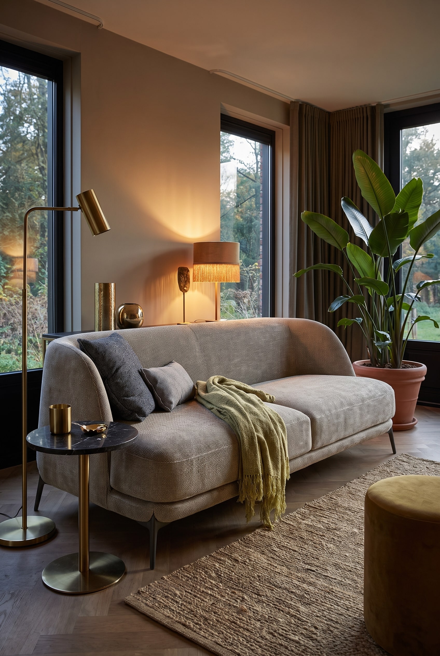 Salon de style Boho-Glamour avec un canapé en velours de forme organique dans une teinte chaude, complété par des détails en laiton et de grandes plantes