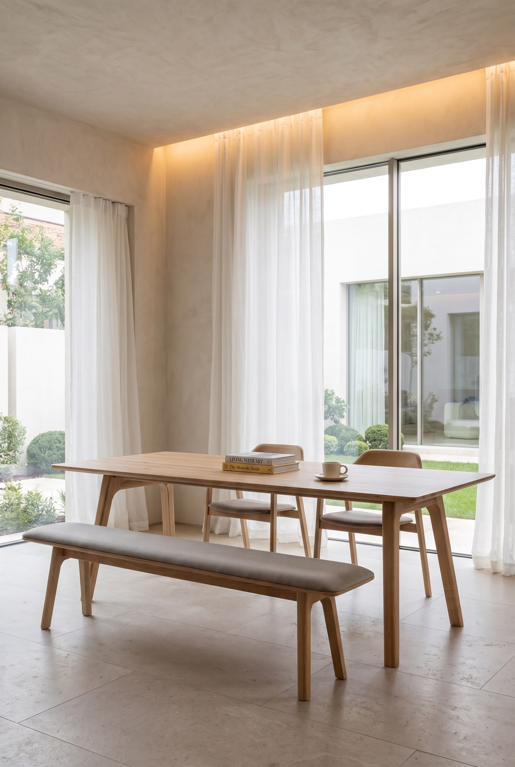 Salle à manger spacieuse avec une table à manger en bois, un banc en bois rembourré d'un côté et des chaises de salle à manger individuelles de l'autre.