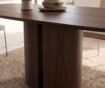 Table à manger design al2 el-it c 001 en placage bois foncé avec piétement cylindrique dans une salle à manger.