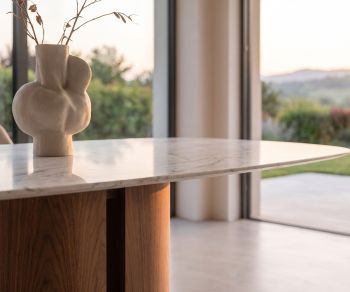 Table de repas al2 el-it c 001 dans une salle à manger moderne avec plateau aspect marbre blanc, pied en bois et vase.