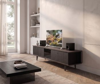 Meuble TV lowboard Ozzio Brera en chêne noir avec porte en verre fumé dans un salon moderne et lumineux.